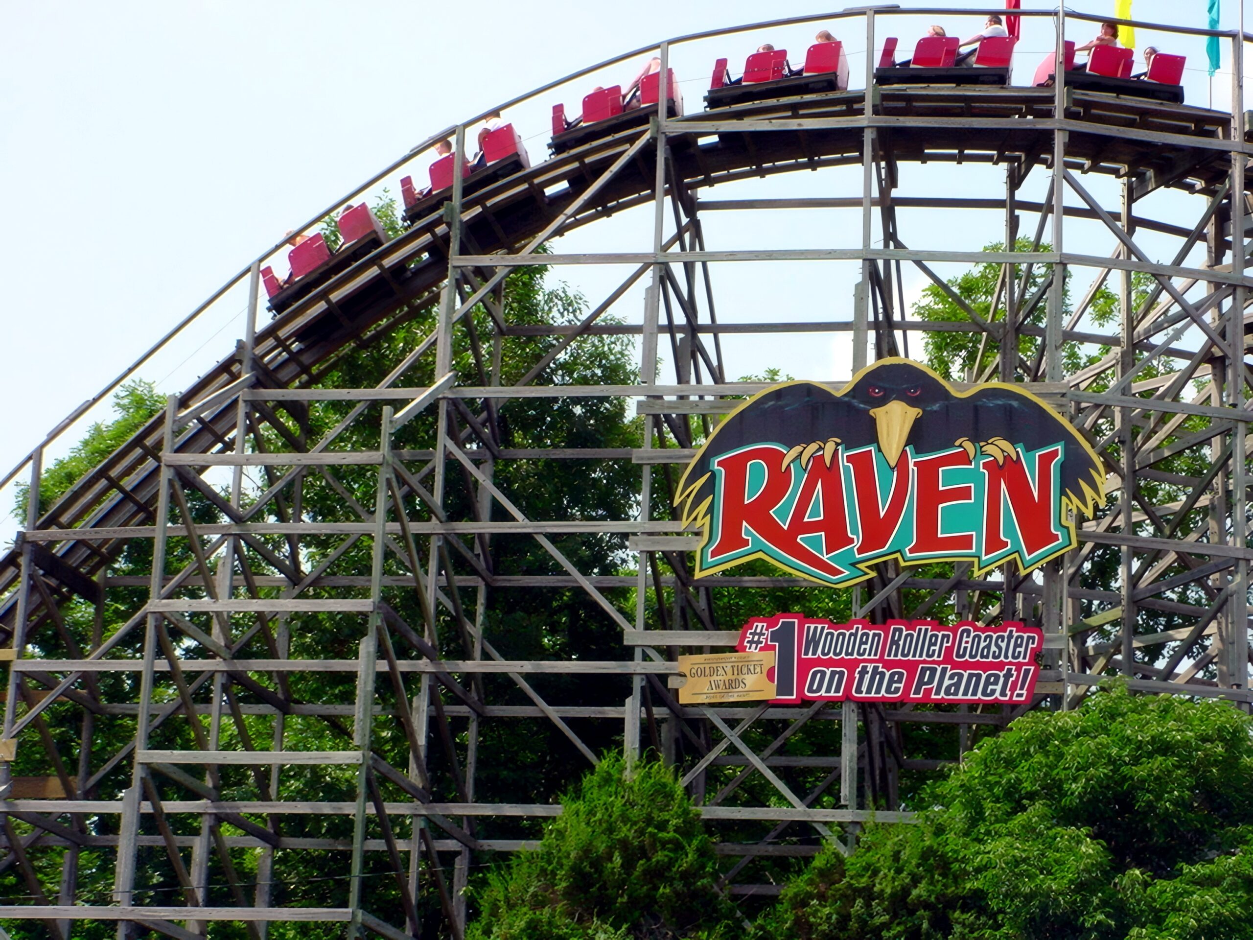 A Raven train cresting the lift hill above the ride sign, July 2002