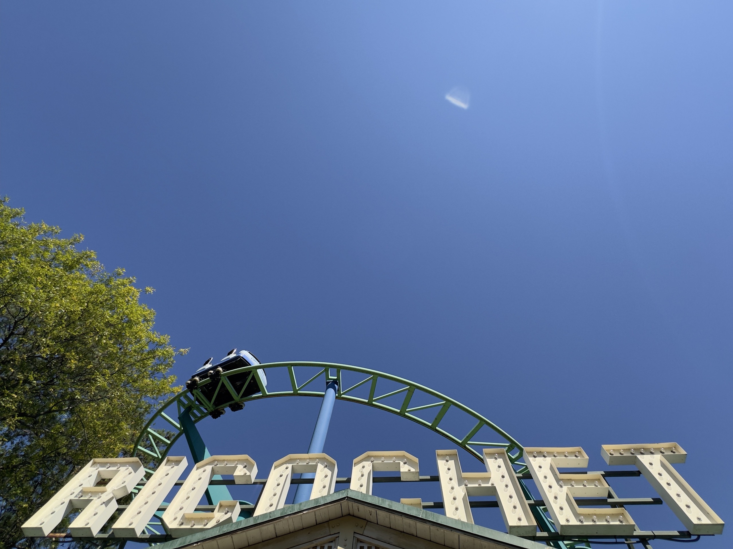 A Ricochet car rounding the green track above the marquee, Carowinds, October 2024