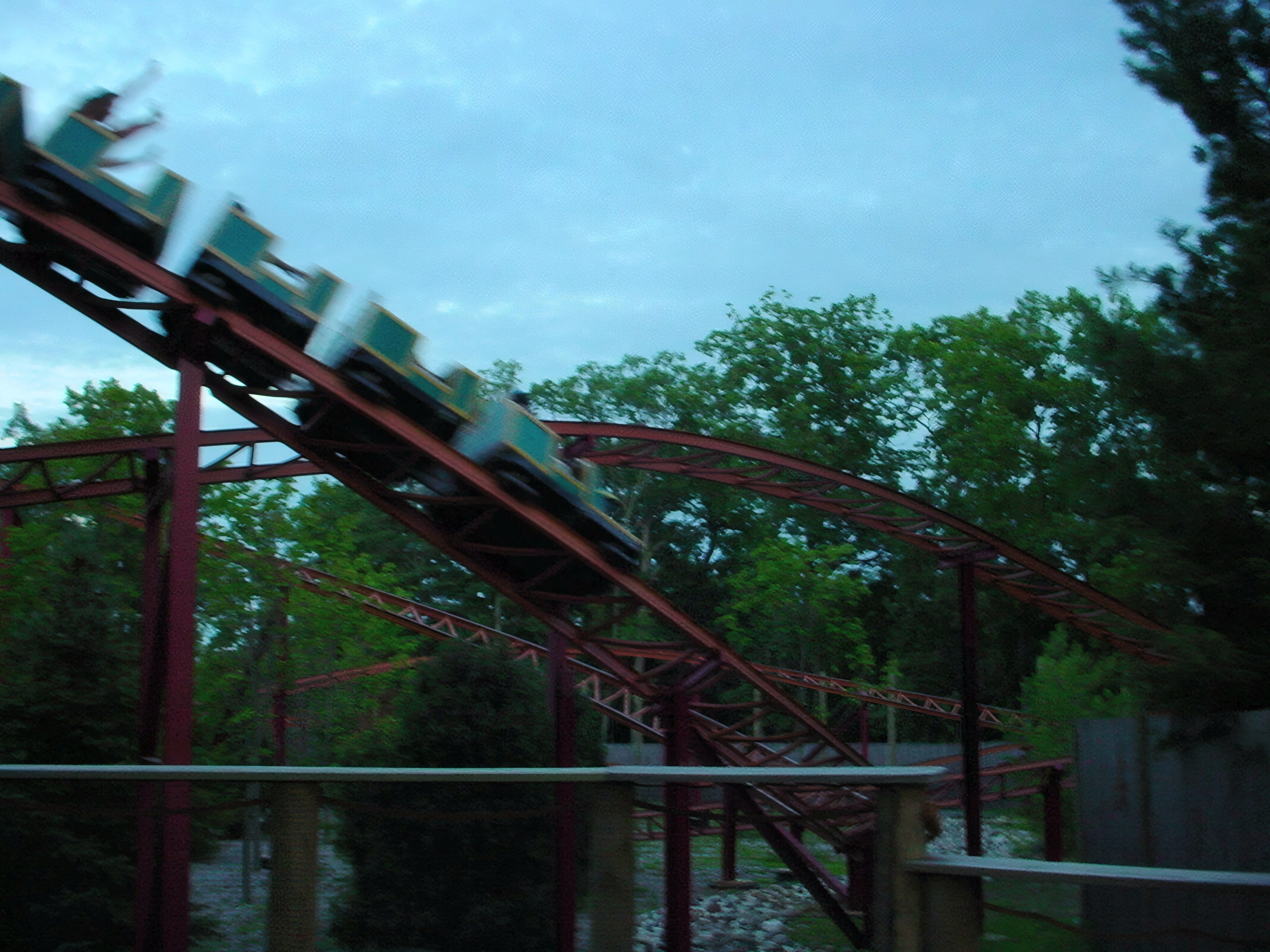 Bobsled-style coaster train diving down red steel track at dusk, Sarajevo Bobsled, July 2001