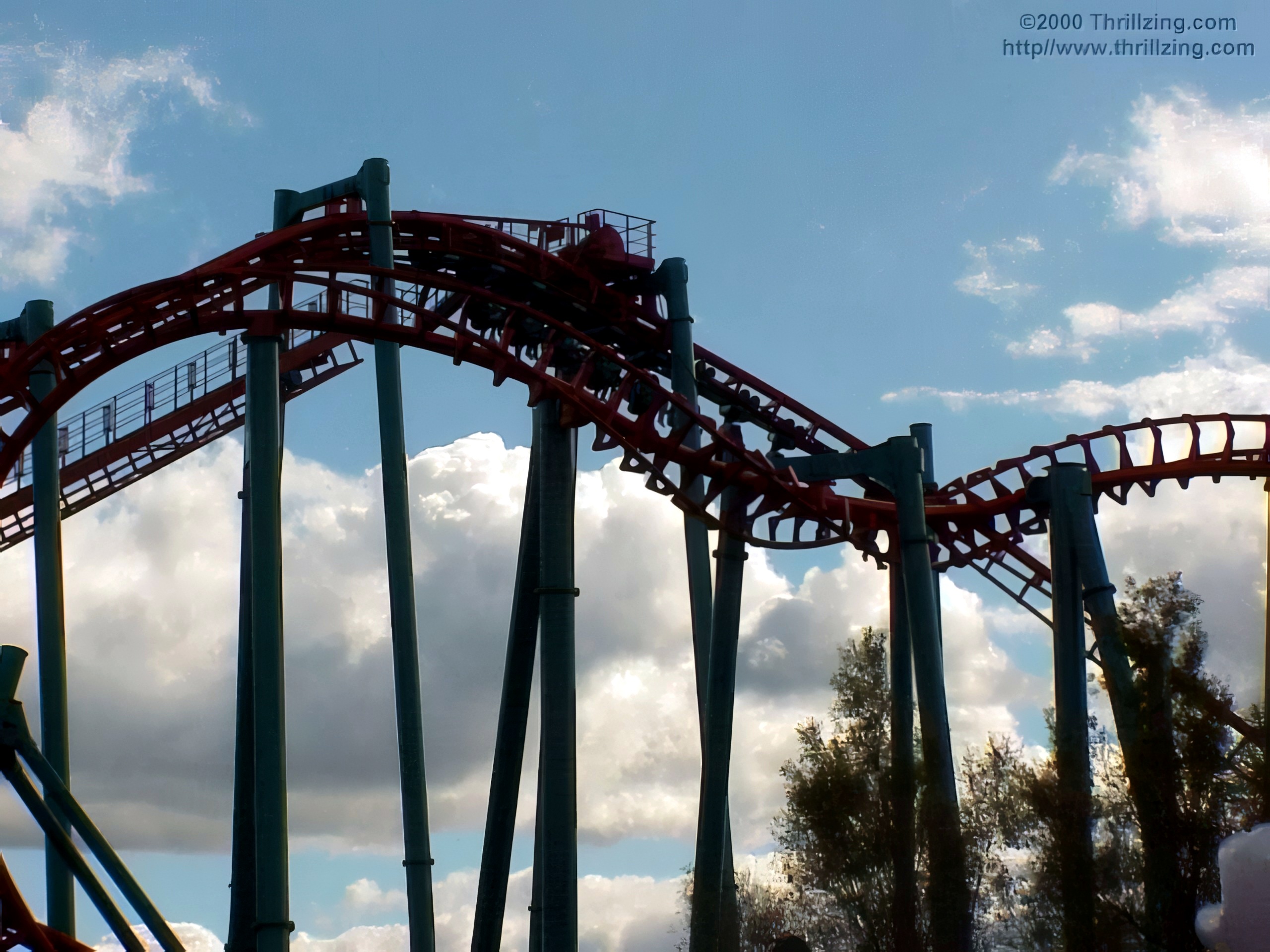 Red steel coaster S-curve track against cloudy sky, Serial Thriller, May 2000