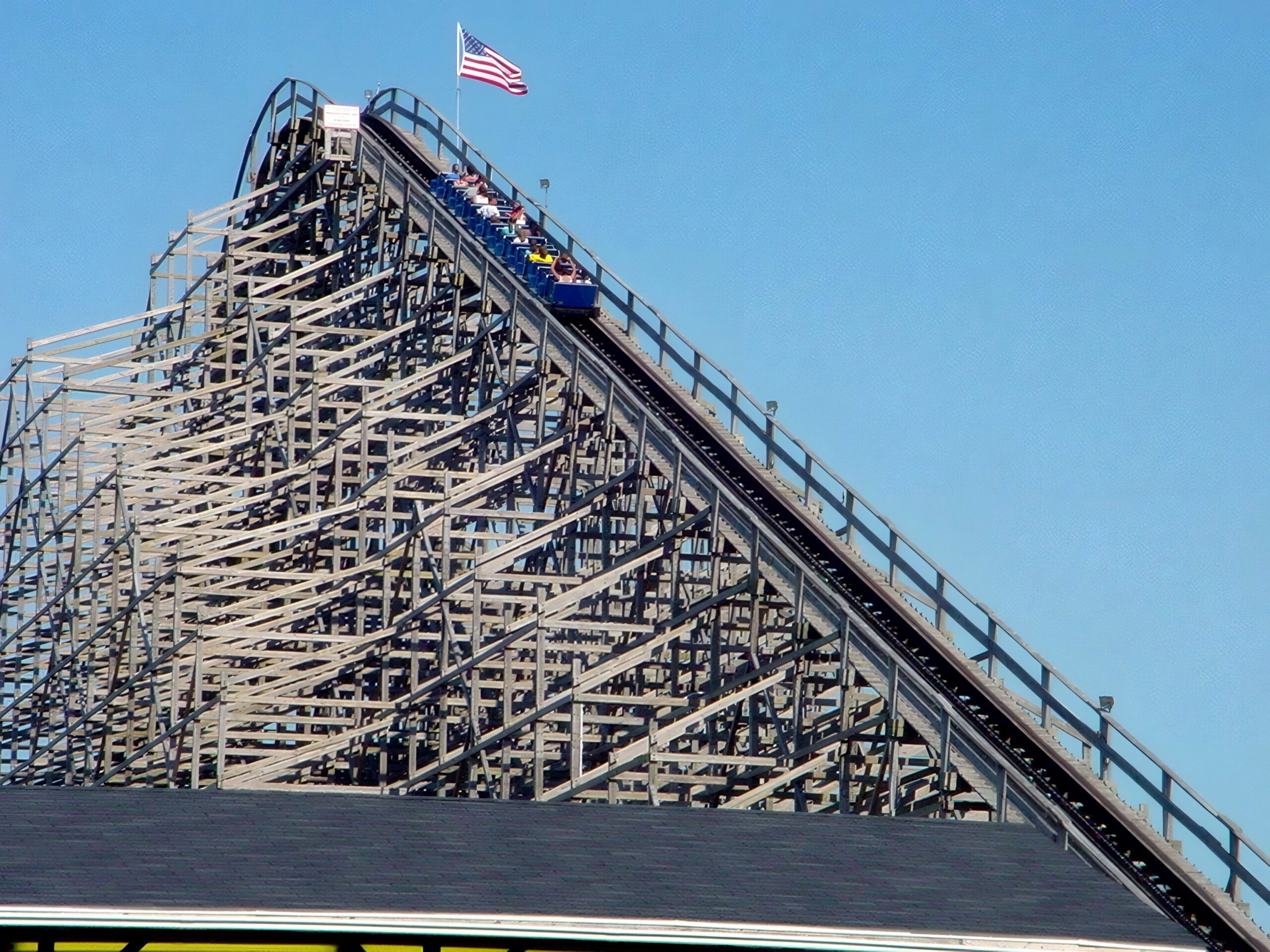 A Shivering Timbers train climbing the 122-foot lift hill beneath the flag, June 2002