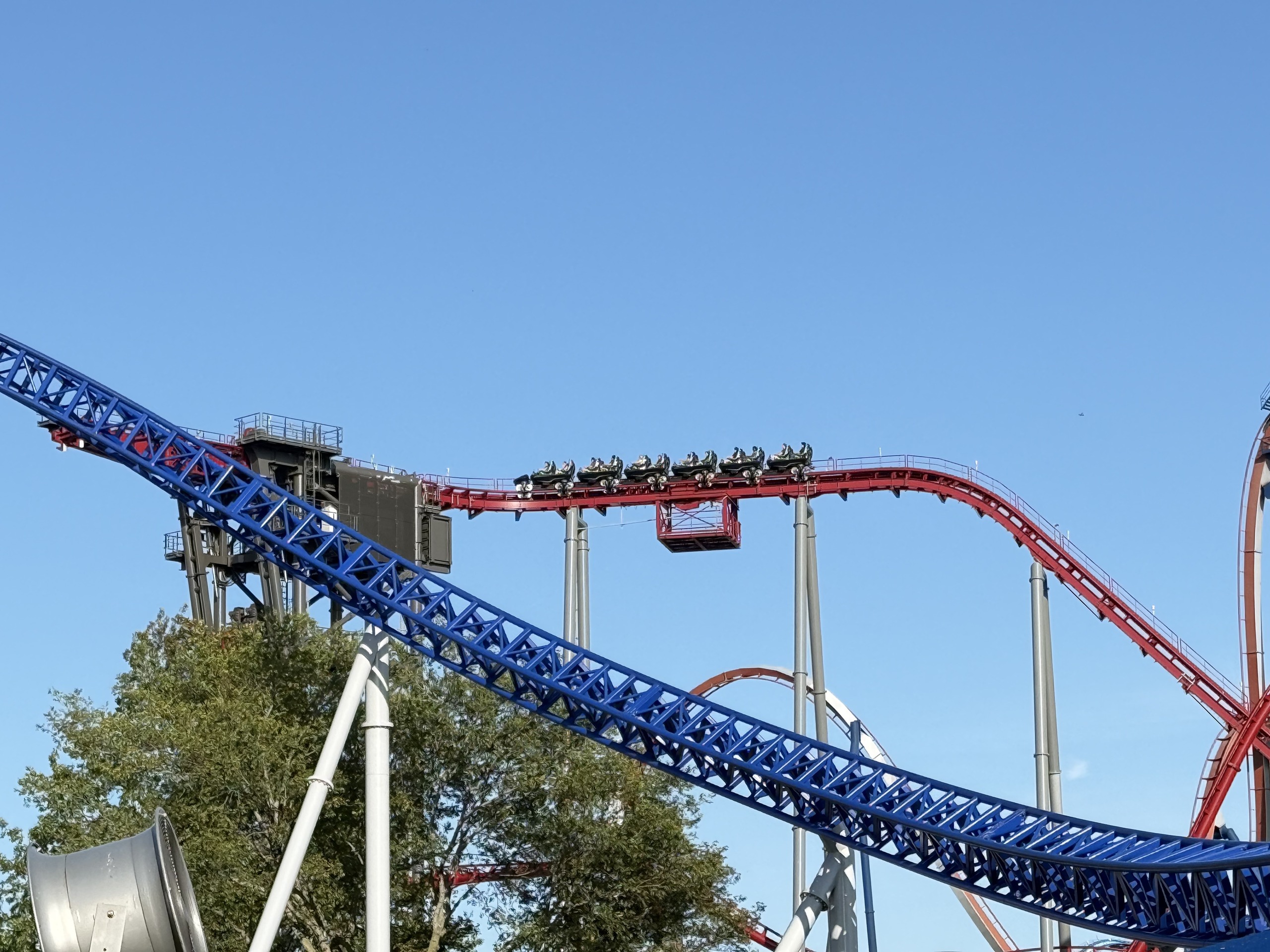 A Siren's Curse train on the red track beyond Millennium Force's blue lift truss