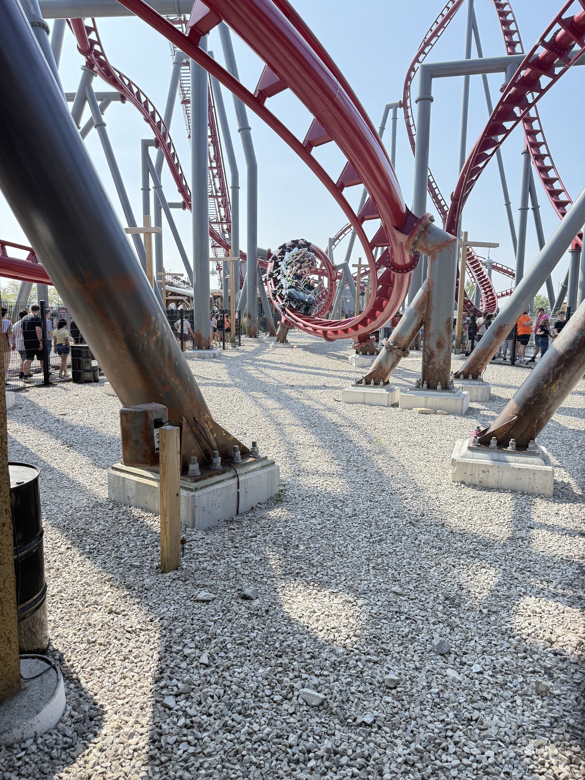 A Siren's Curse train mid-inversion on the red track with the queue behind