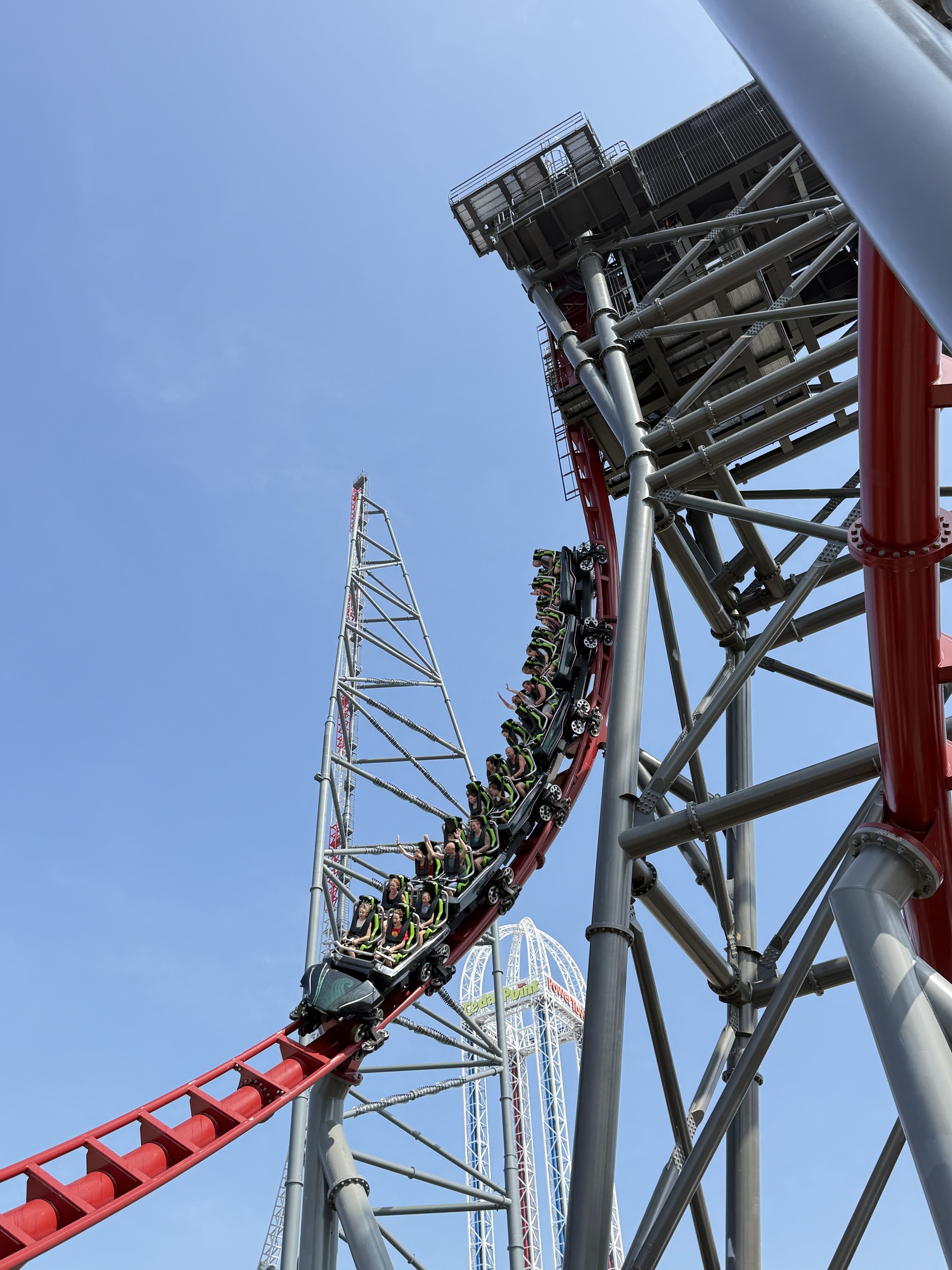 A Siren's Curse train pulling out of the vertical drop with riders' arms up