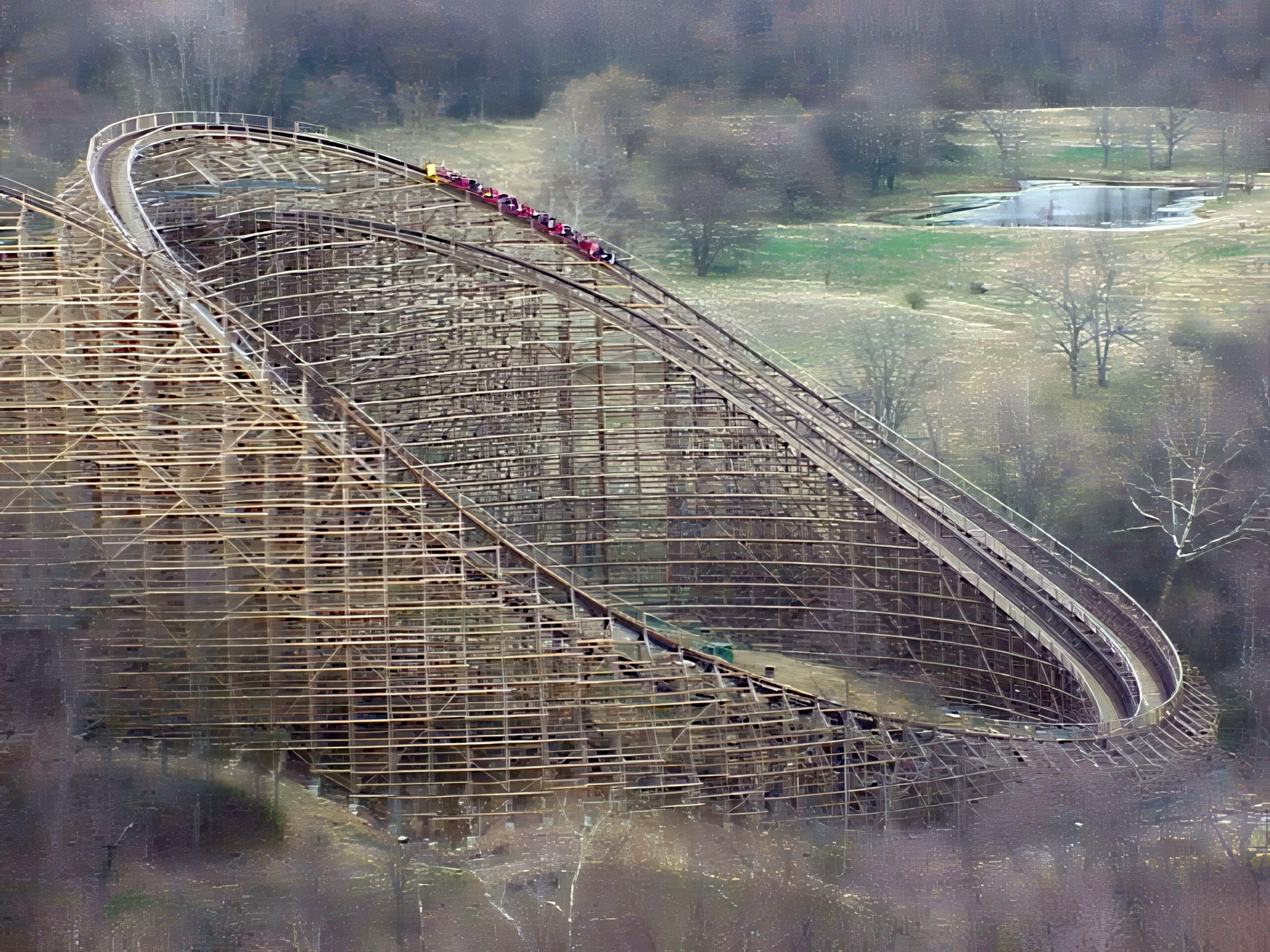 A Son of Beast train diving on the trestle through the bare woods, seen from the Eiffel Tower at Kings Island, April 2001