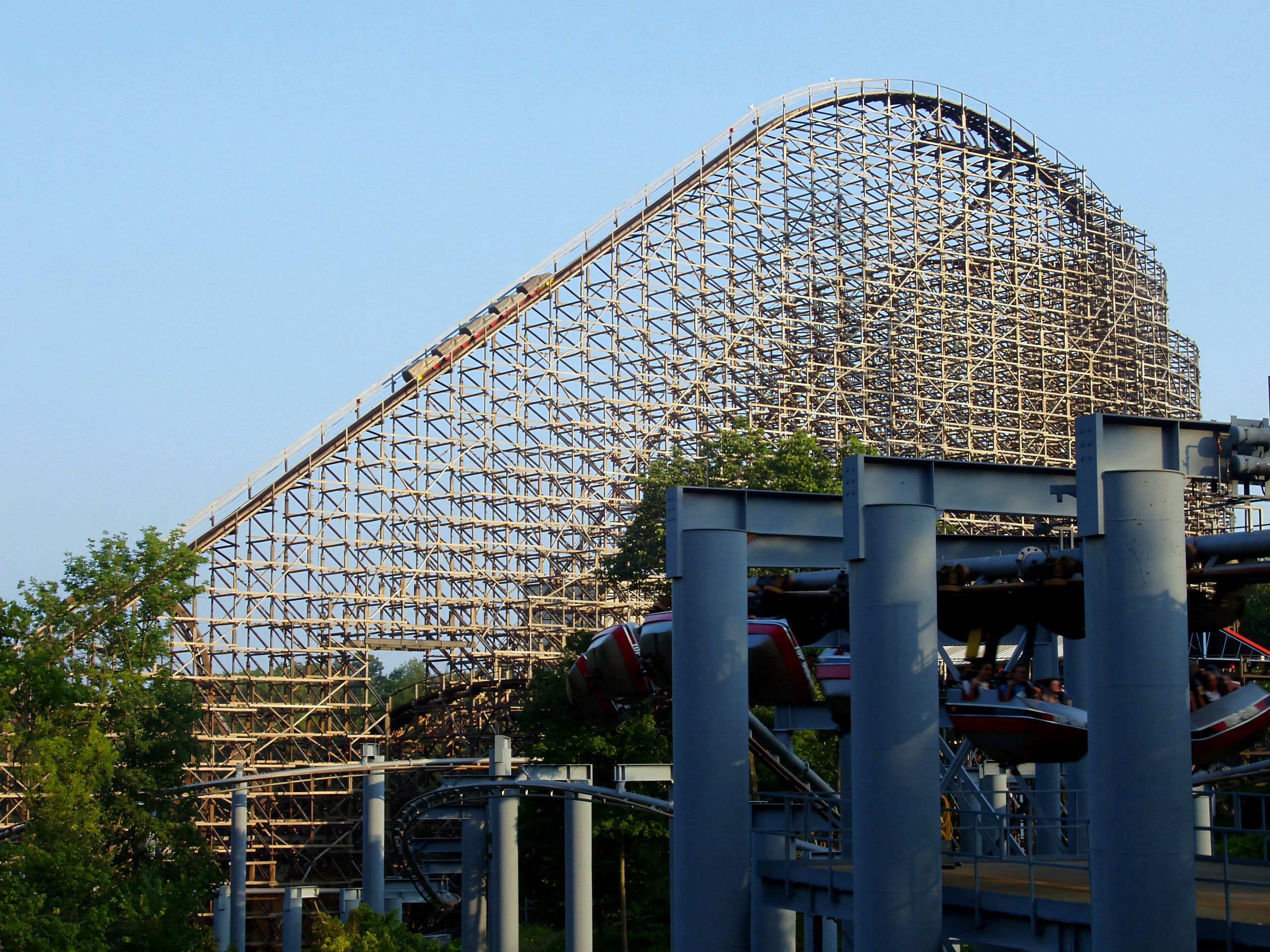 A Son of Beast train topping the hill behind Top Gun's supports and trains at Kings Island, August 2006