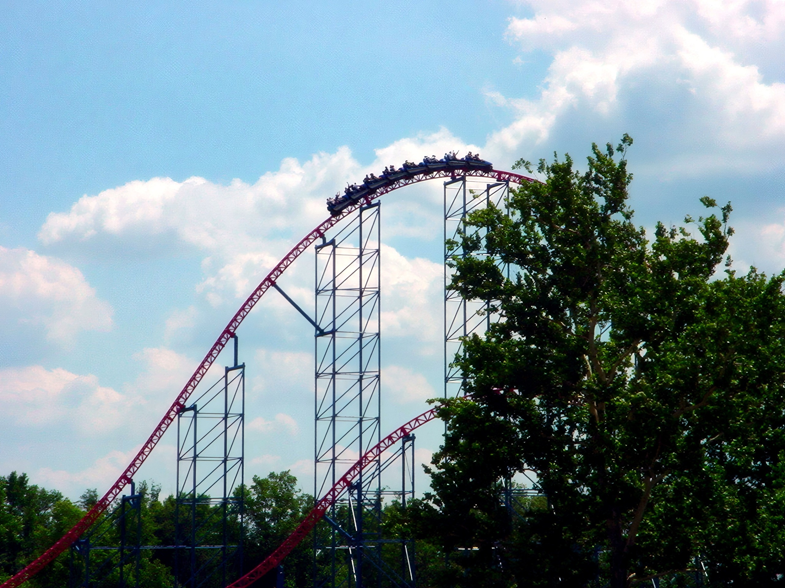 A Superman: Ride of Steel train on a distant hill above the trees at Six Flags America, July 2001