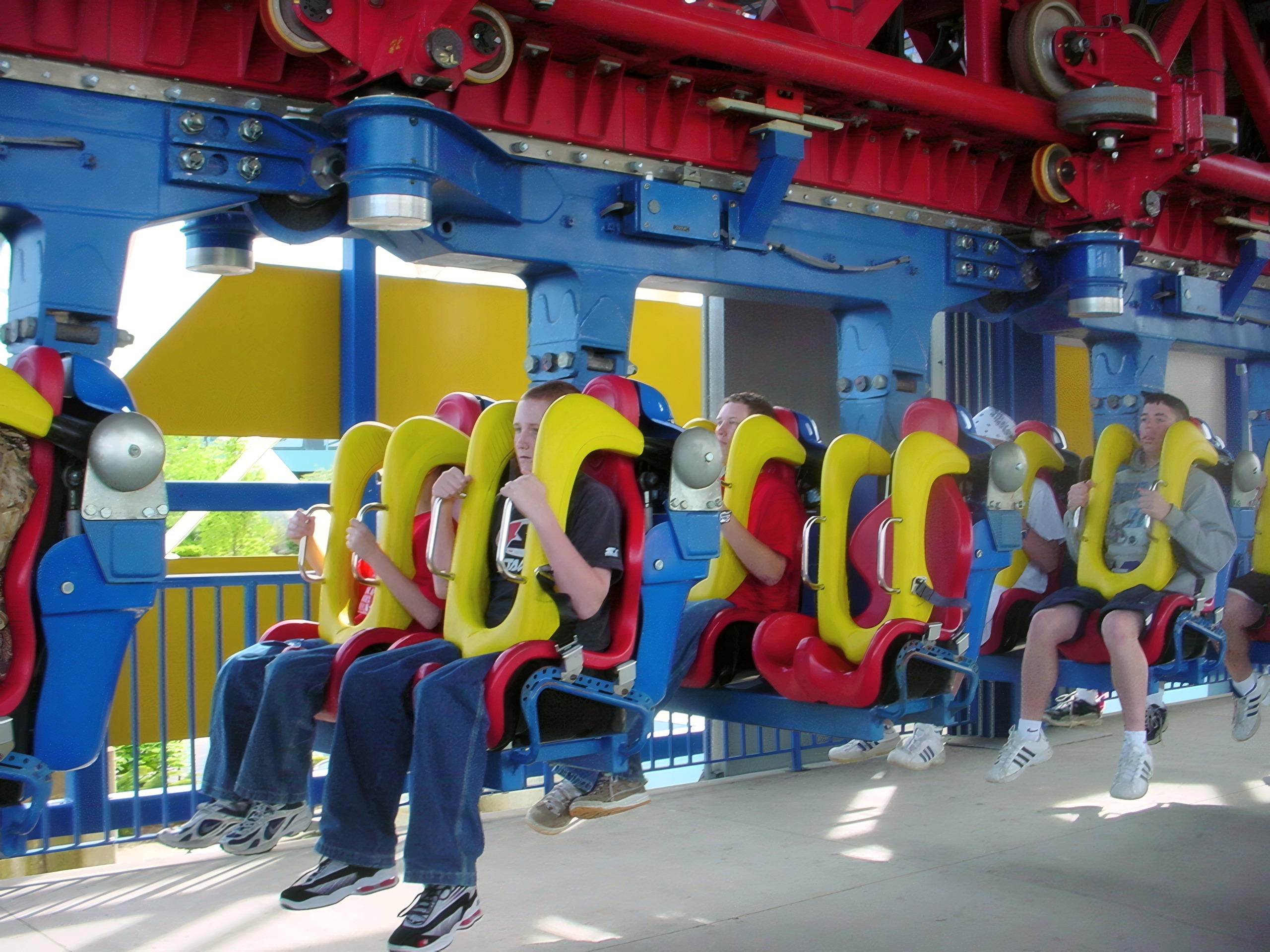 Riders seated in the inverted train in the Superman: Ultimate Escape station, May 2002