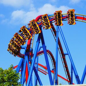 Superman: Ultimate Flight at Six Flags Great America: a flying coaster train cresting a turn in the sun above the blue supports