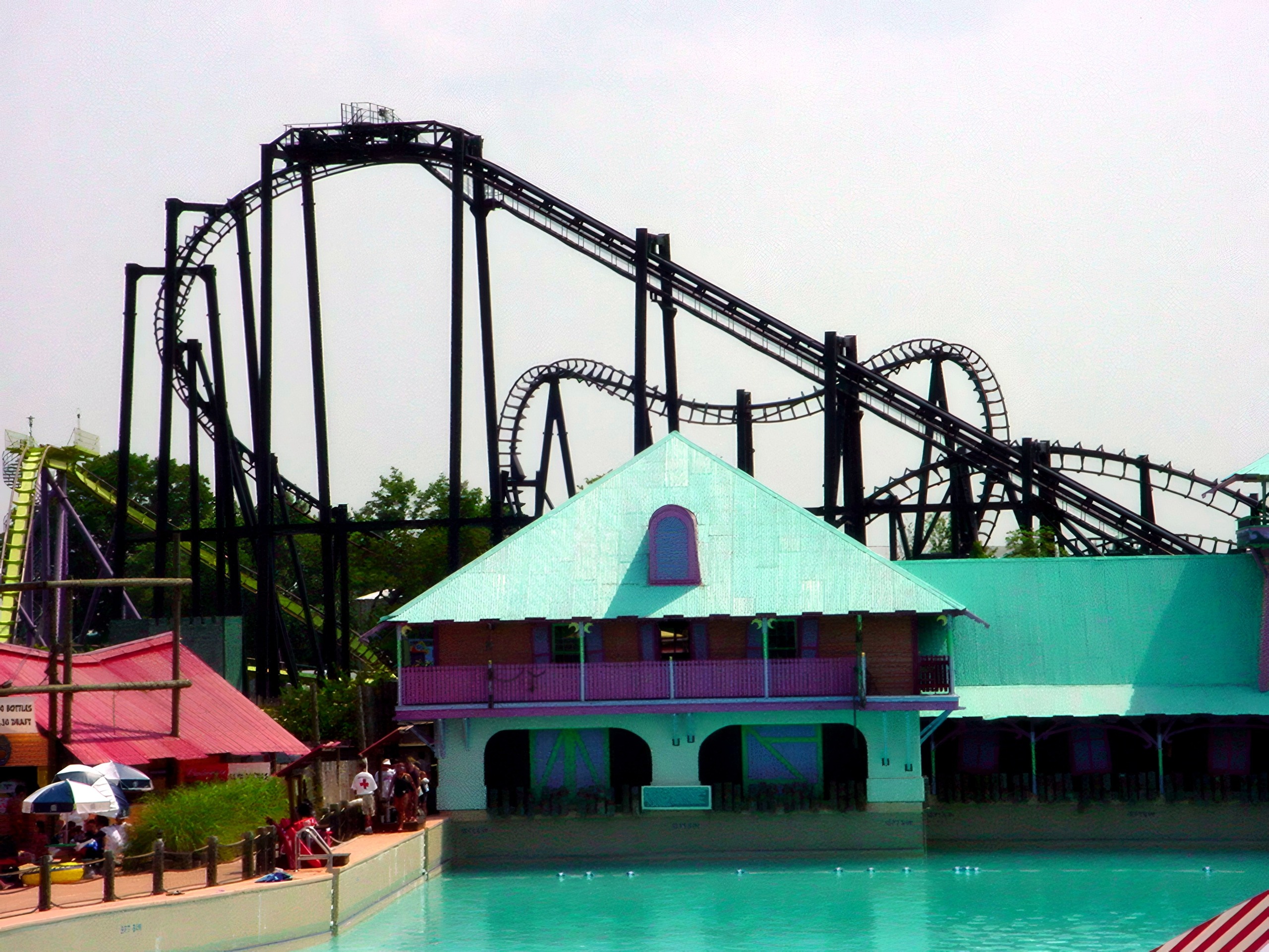 Black inverted-loop coaster over turquoise pool building, T2, July 2002