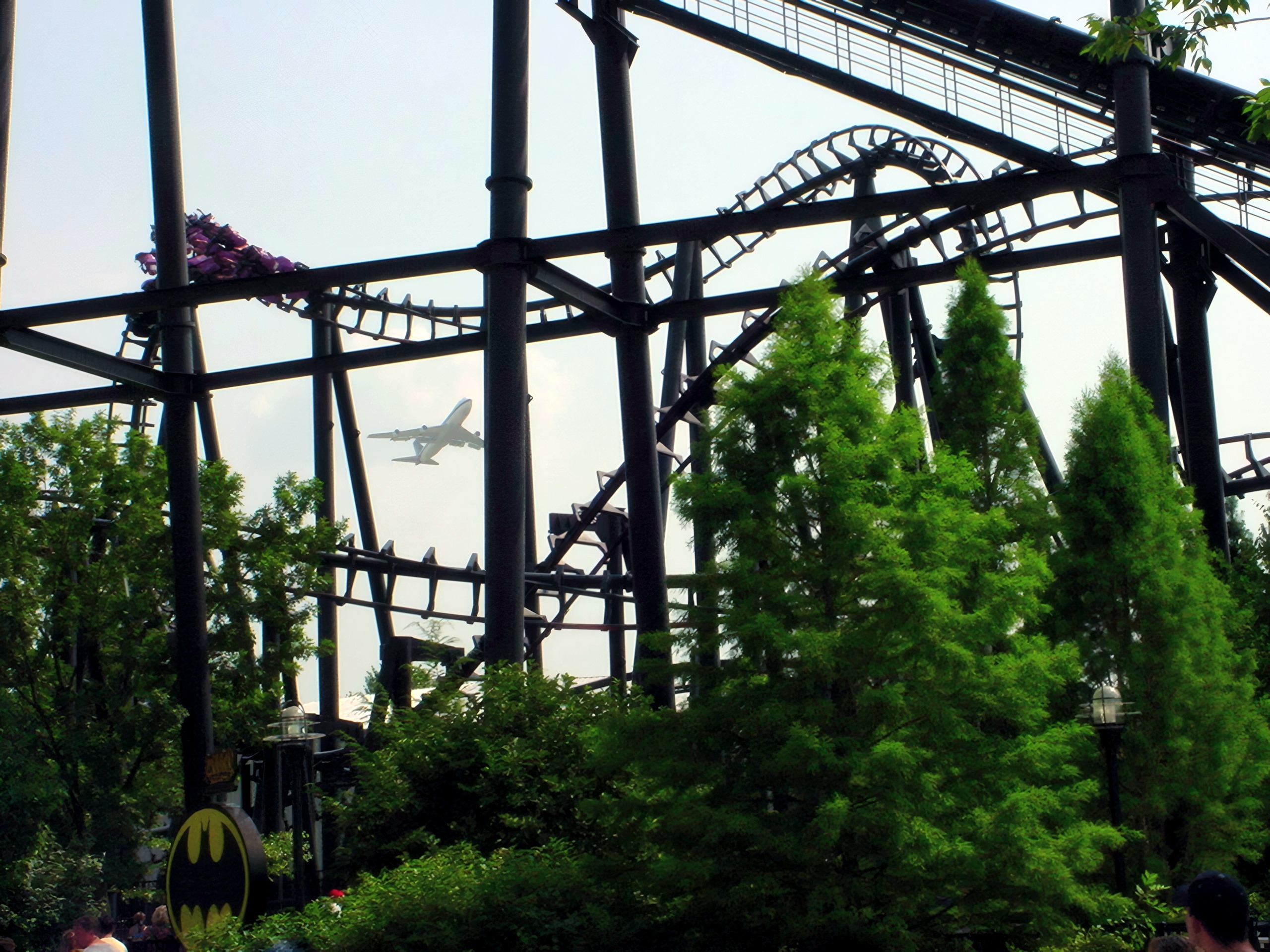 Inverted coaster train on track with airplane flying overhead, T2, July 2002