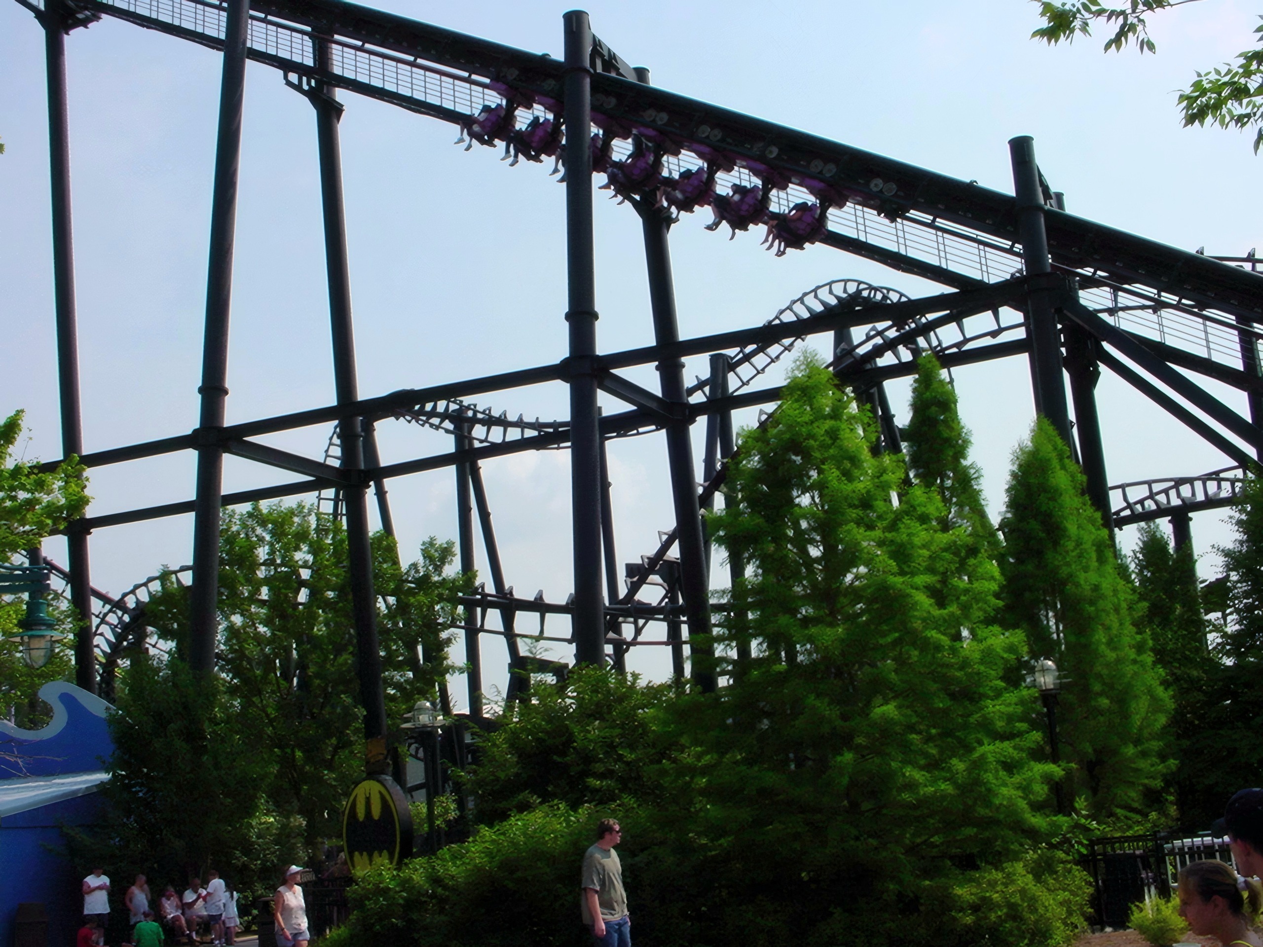 Inverted coaster train winding through black steel track and trees, T2, July 2002