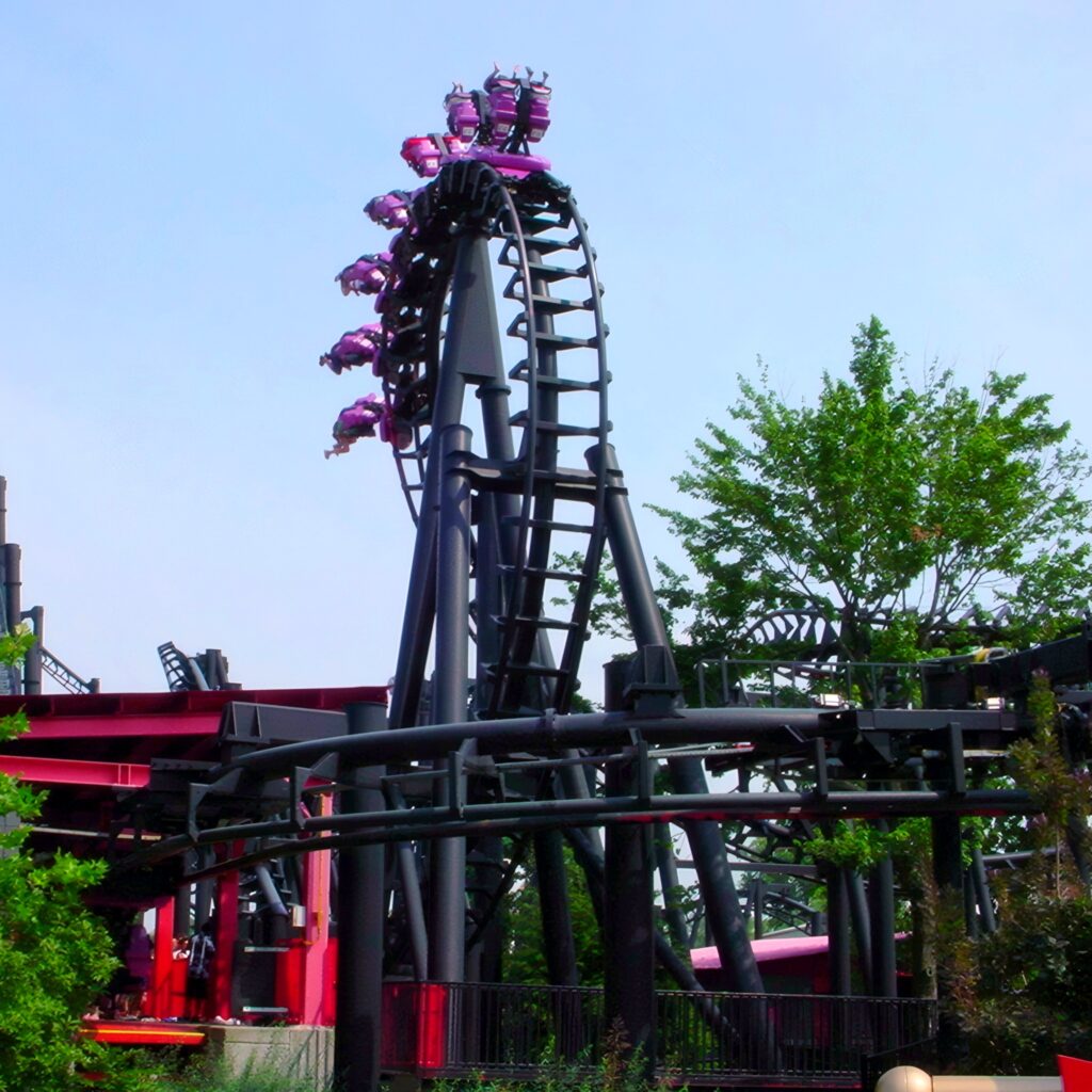 T2 at Six Flags Kentucky Kingdom: an inverted train on the drop beside the red station