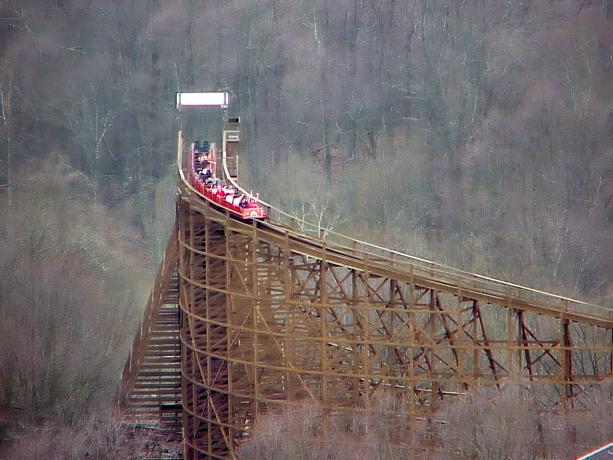 A red Beast train topping the second lift hill above the bare woods, seen from the Eiffel Tower at Kings Island, April 2001