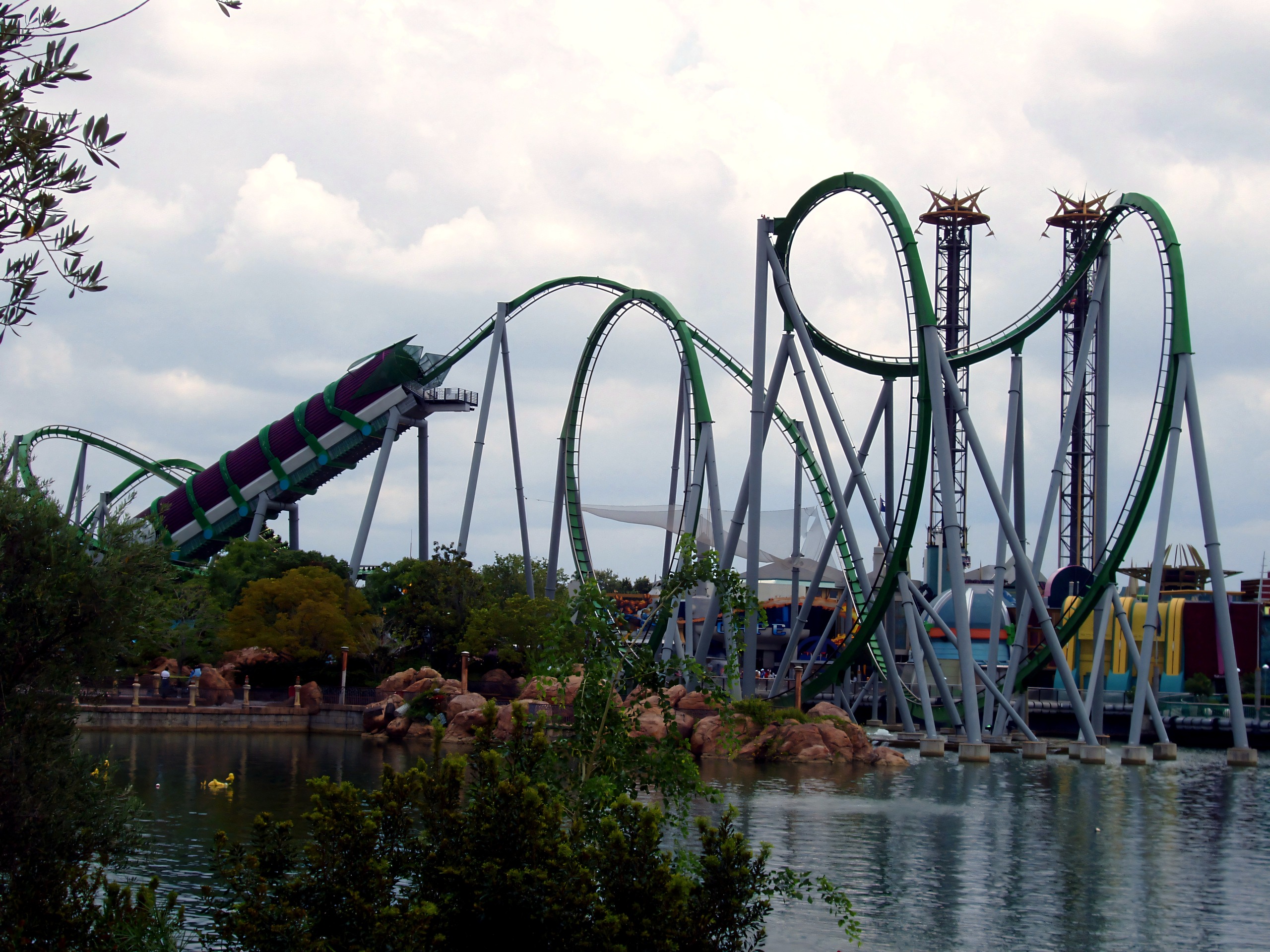 Loops over the lagoon rocks under a cloudy sky, The Incredible Hulk Coaster, July 2006