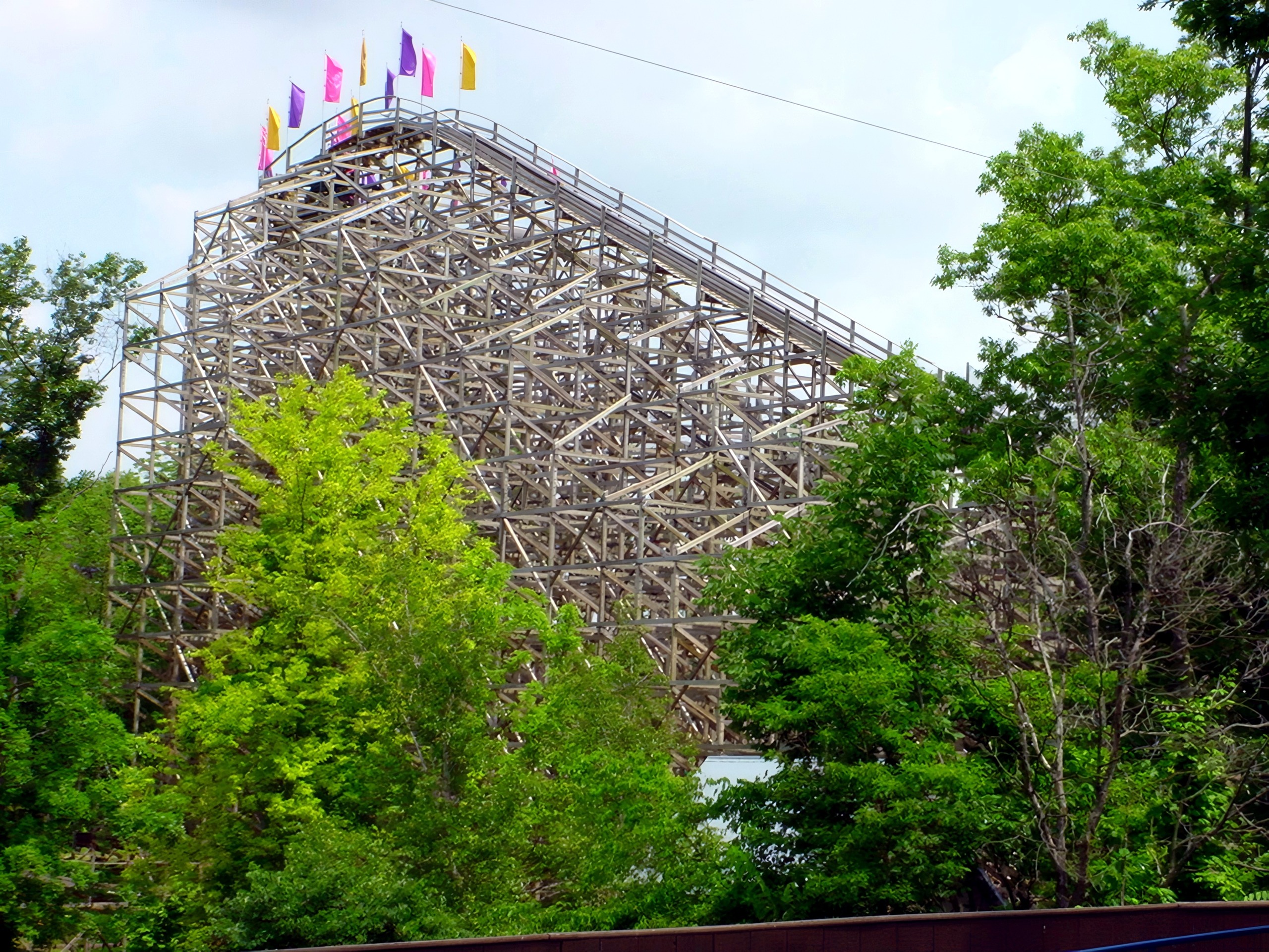The Legend's lift hill and flagged summit above the trees, July 2002