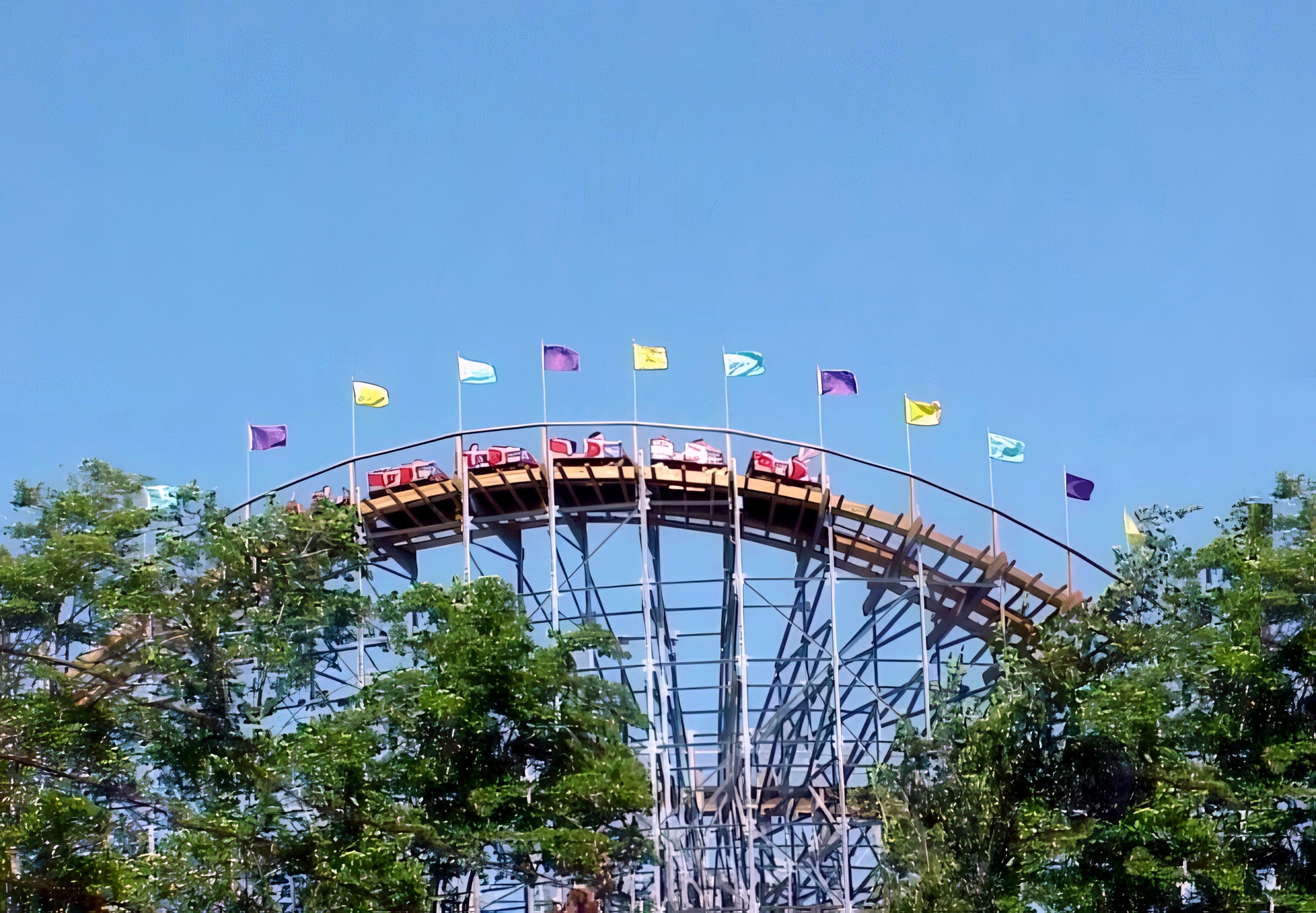 A Villain train banking through a turn under the flags at Geauga Lake, May 2000