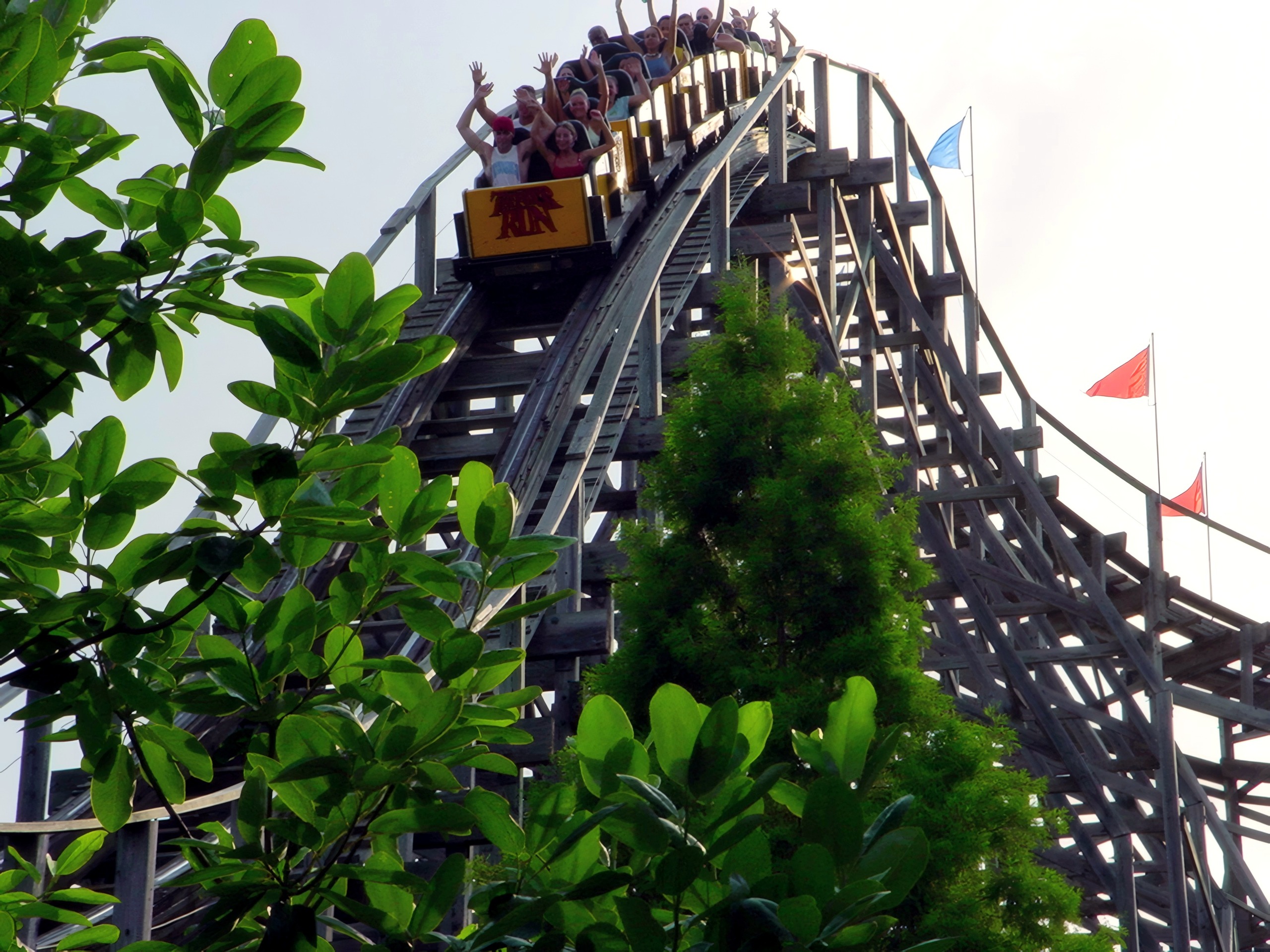 A Thunder Run train of riders with arms raised cresting a hill at Six Flags Kentucky Kingdom, July 2002