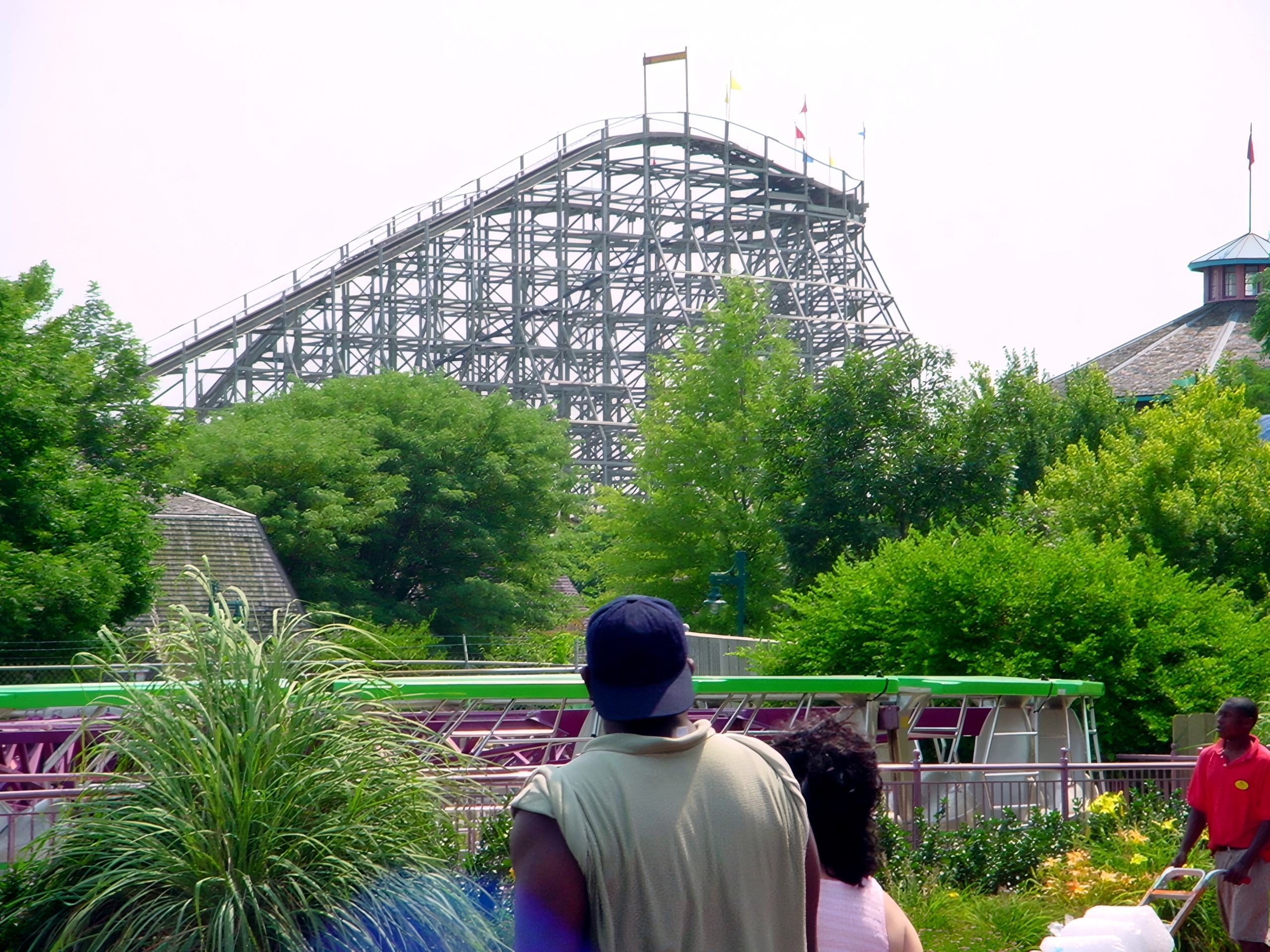 Thunder Run's lift hill above the trees with guests on the midway at Six Flags Kentucky Kingdom, July 2002