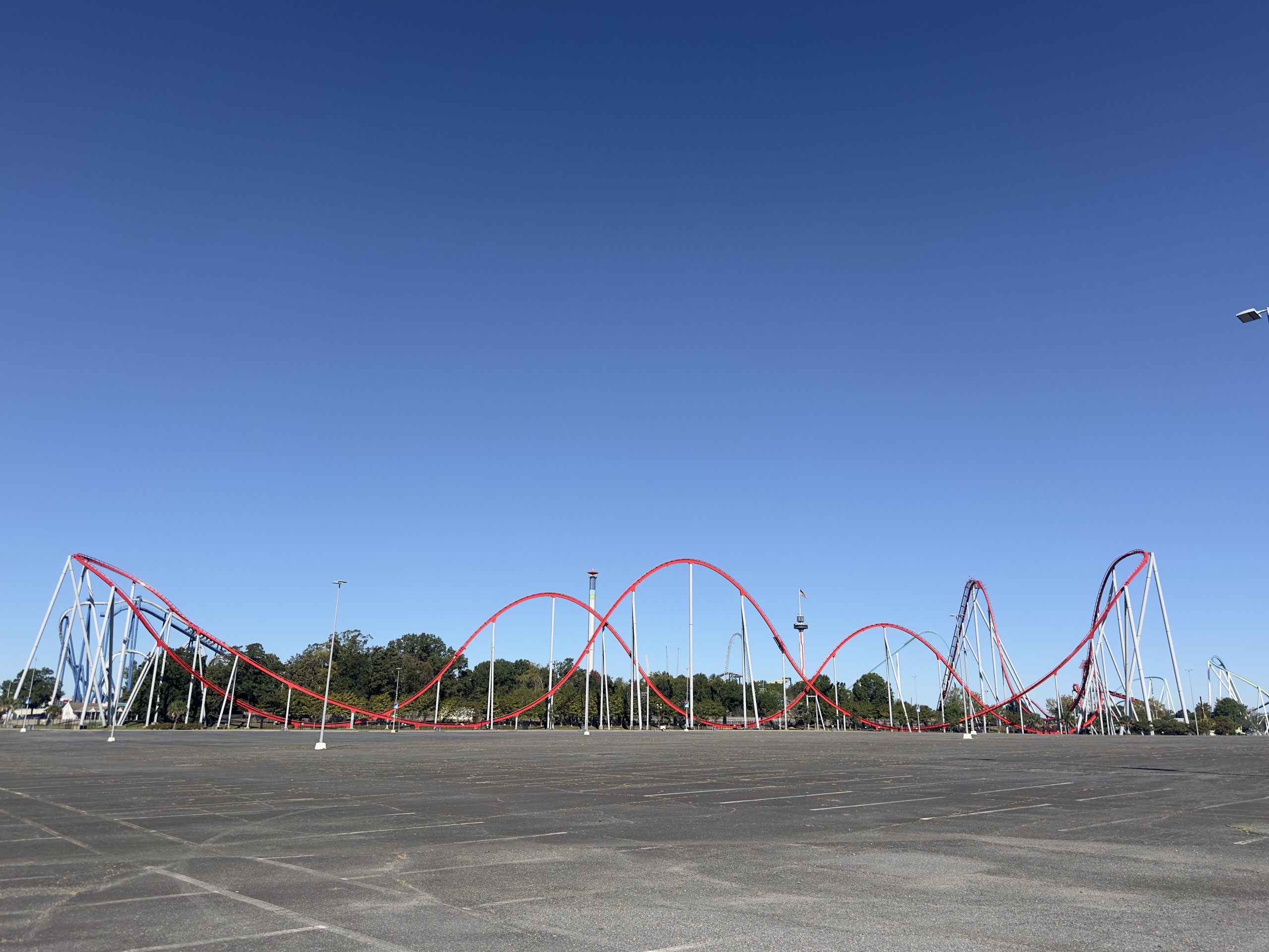 Thunder Striker's red track and airtime hills across the empty Carowinds parking lot, October 2024