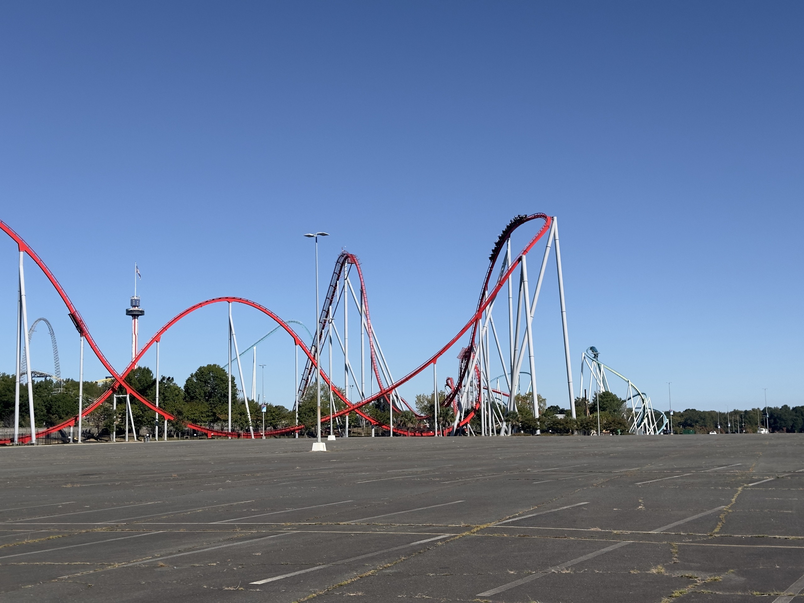 A Thunder Striker train high on the layout with the red hills below, Carowinds, October 2024