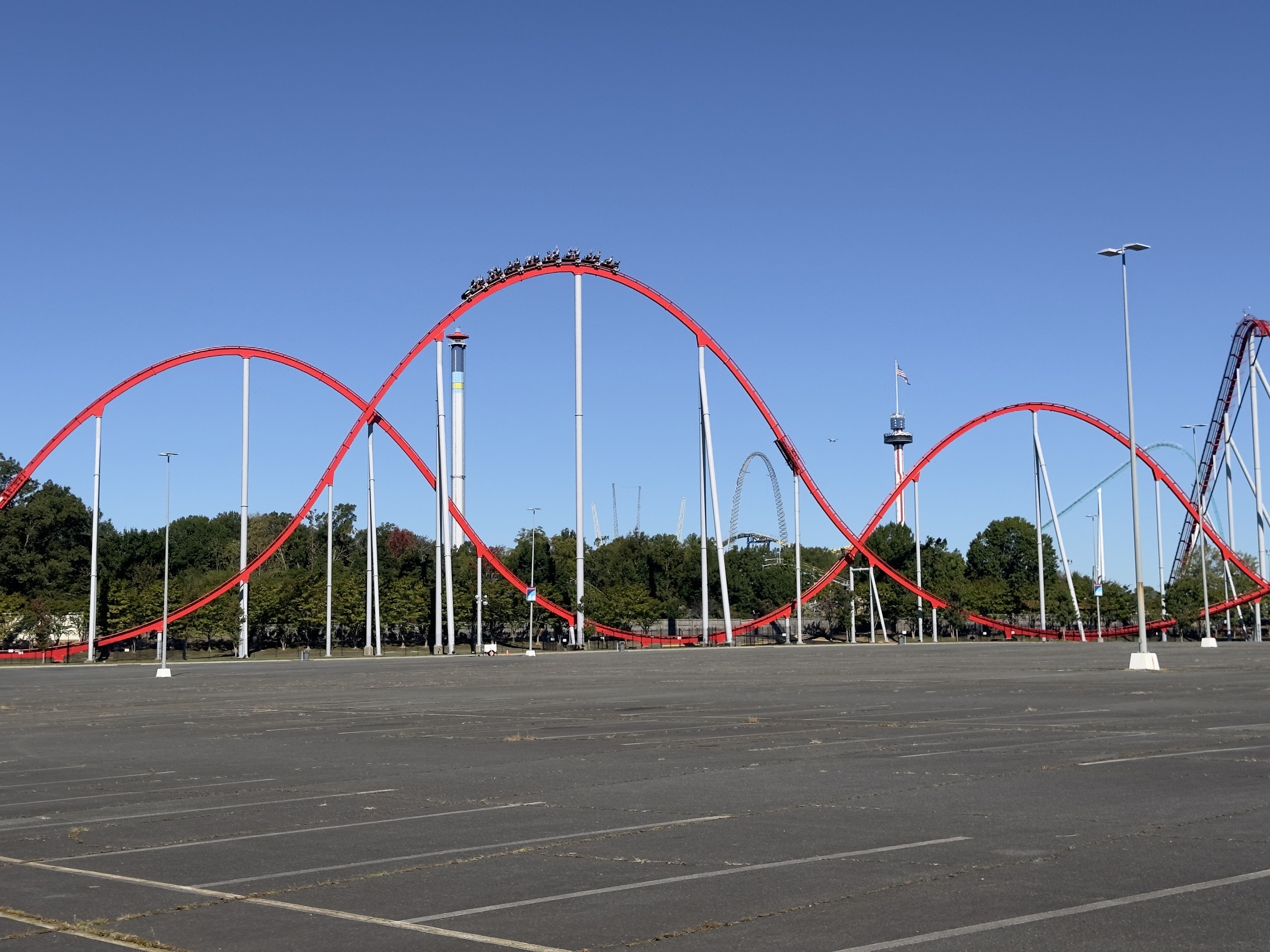 A Thunder Striker train cresting a red airtime hill above the parking lot, Carowinds, October 2024