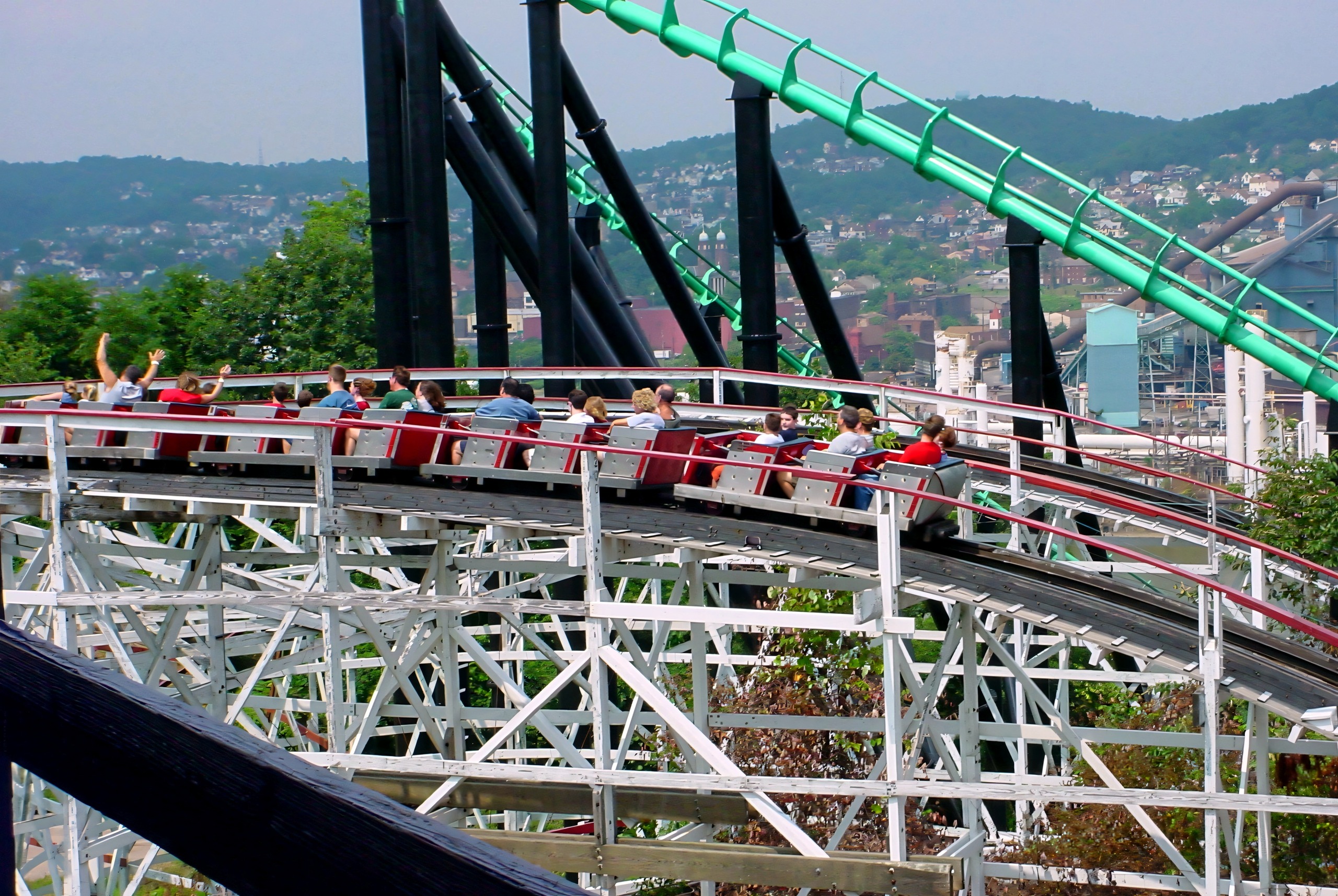 A red Thunderbolt train full of waving riders on the white trestle, July 2003