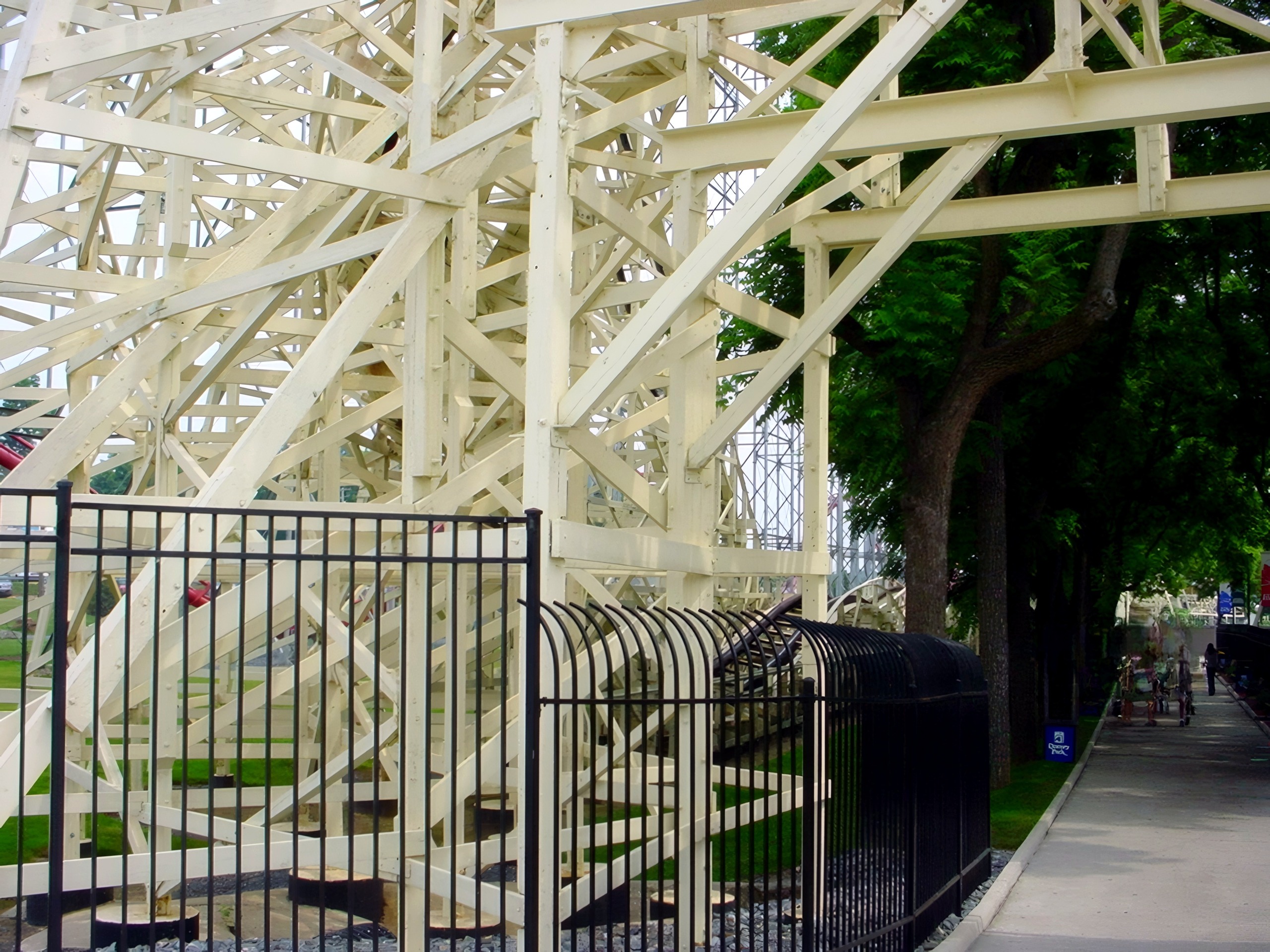 Thunderhawk's structure beside the fence and tree-lined path at Dorney Park, July 2001