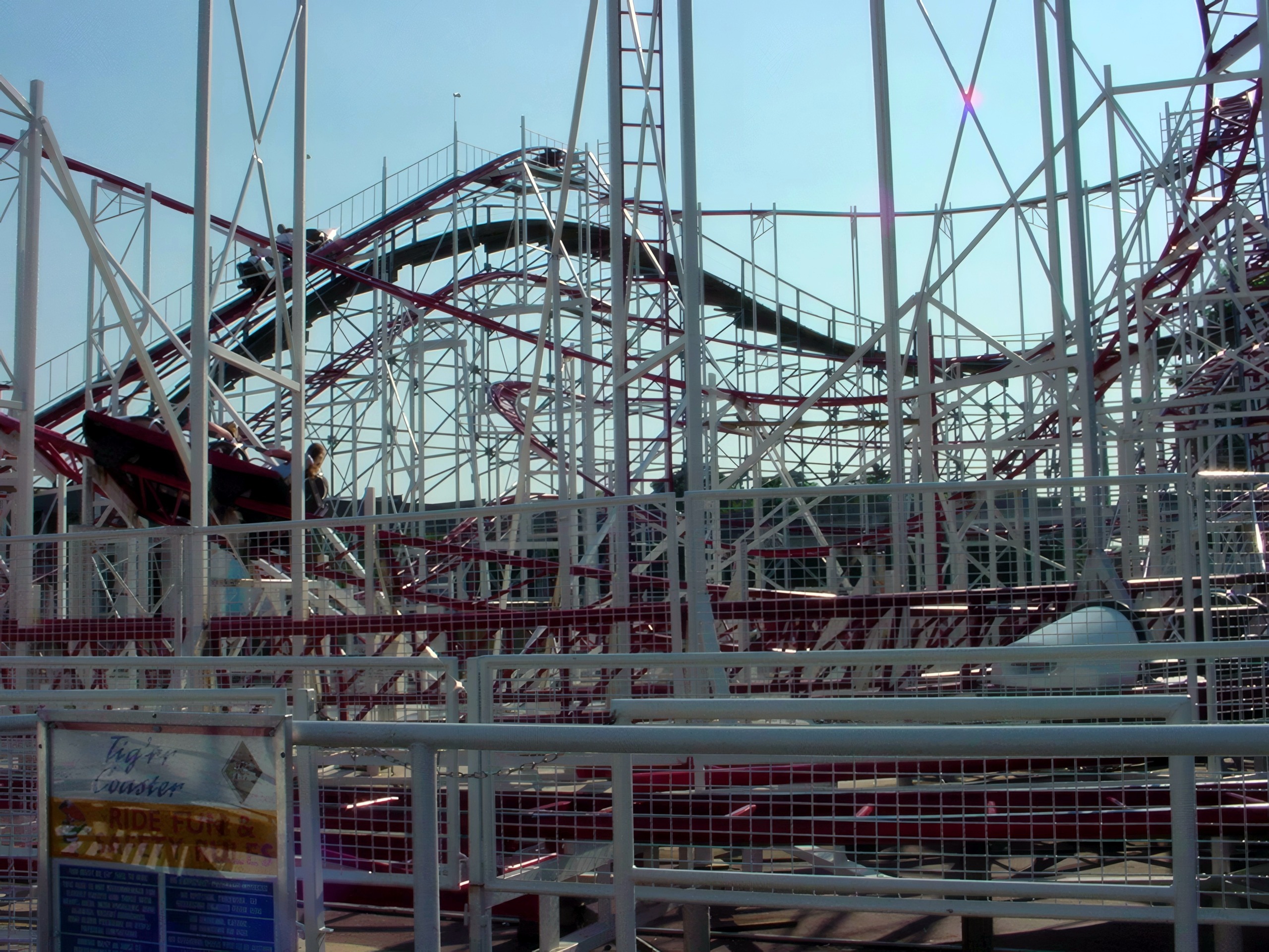 The Tig'rr Coaster's maroon track and white supports above its sign at Indiana Beach, June 2002