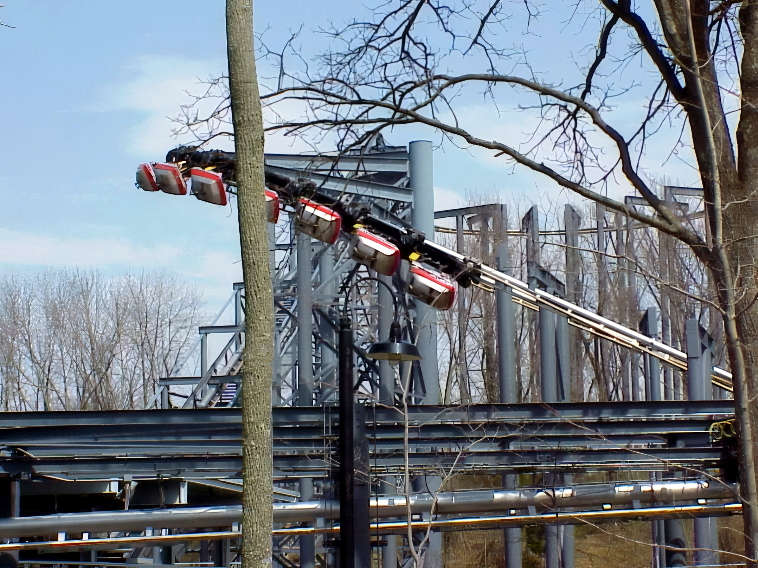 A Top Gun suspended train on the track through the bare woods at Kings Island, April 2001