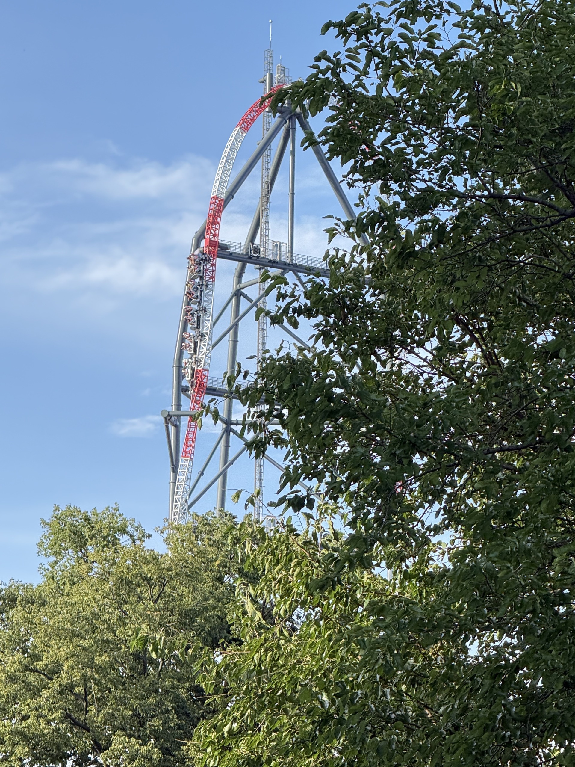 The Top Thrill 2 spike framed by trees with a train near the top