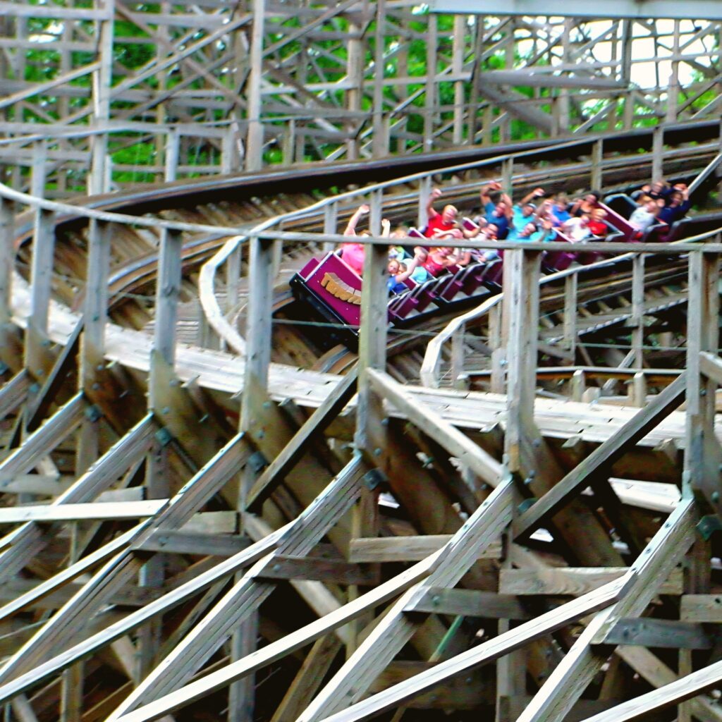 A Twister train full of riders banking through the wooden structure at Knoebels, July 2003