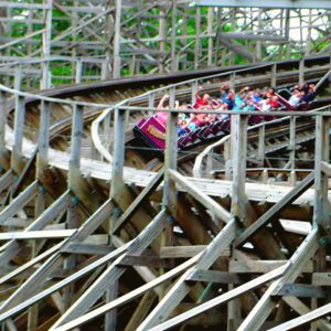 A Twister train full of riders banking through the wooden structure at Knoebels, July 2003