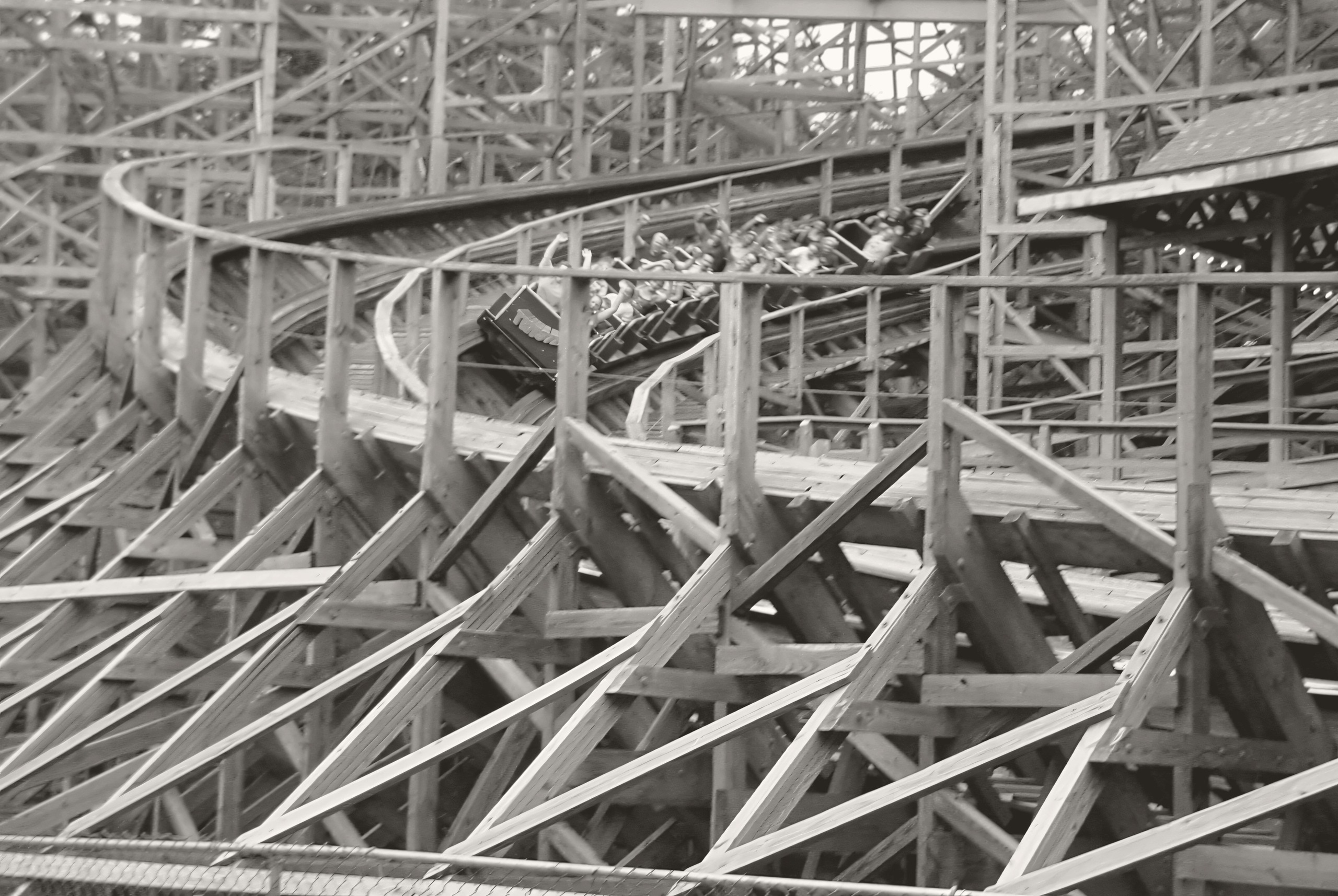 A Twister train banking through the wooden structure at Knoebels in a warm monochrome edit, July 2003