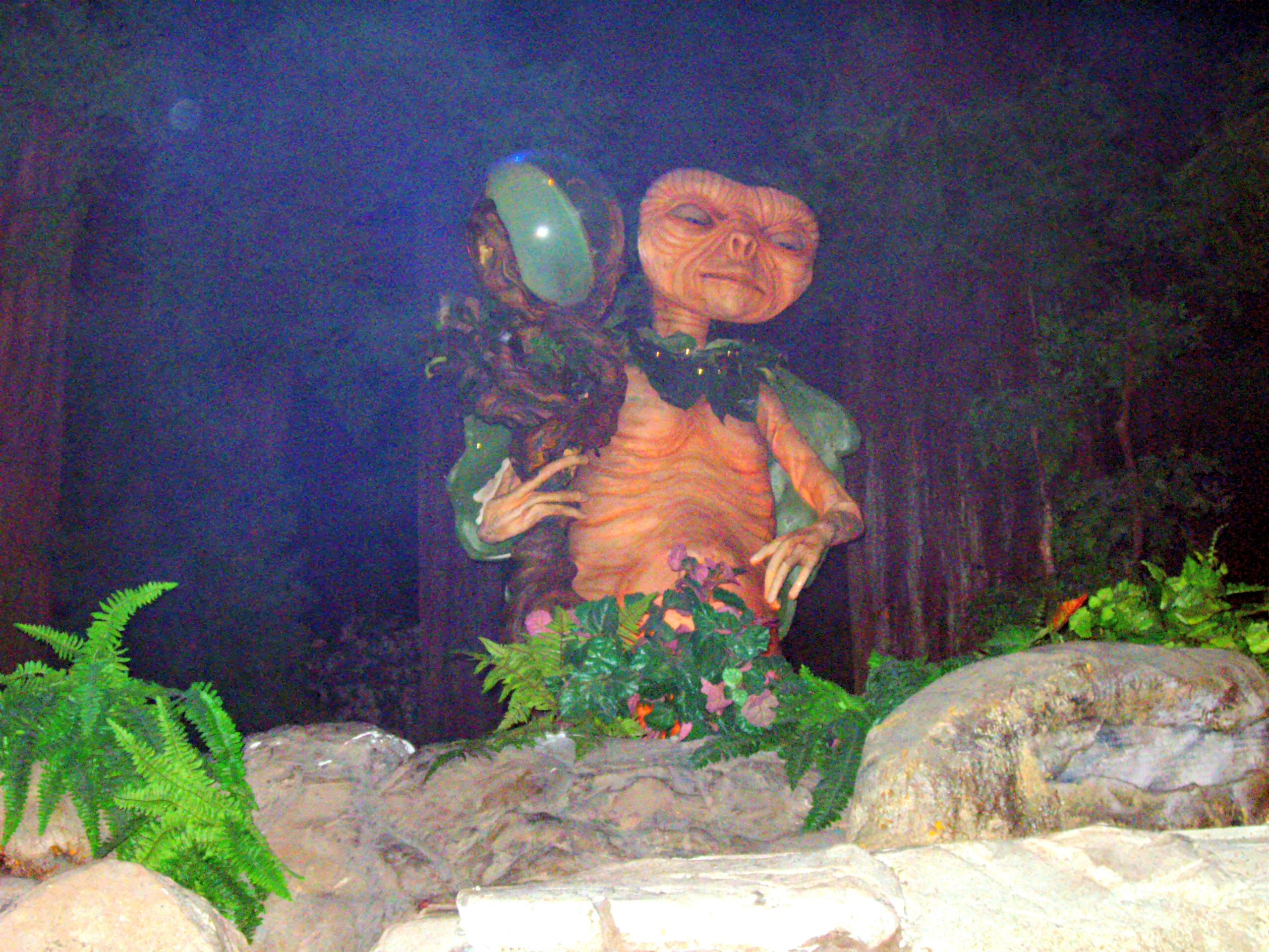 E.T. figure among the ferns and rocks inside the queue, brightened from a low-light original, Universal Studios Florida, June 2006