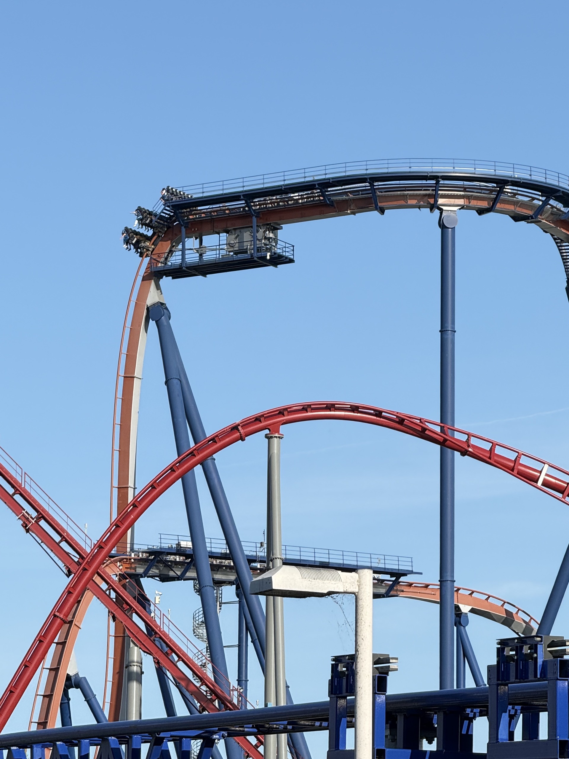 A Valravn train on the holding brake at the top of the drop with Siren's Curse's track in the foreground