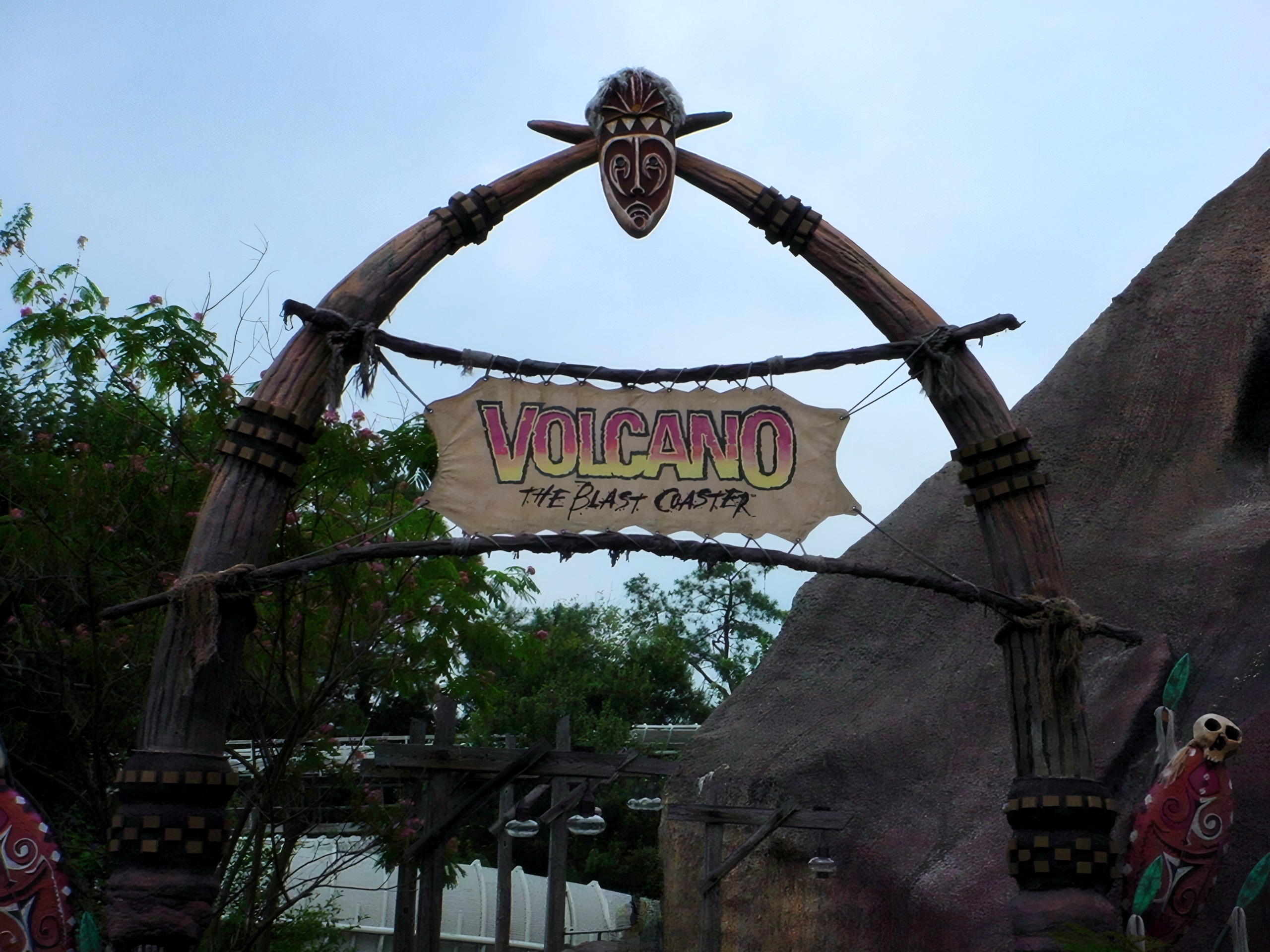 The Volcano: The Blast Coaster entrance arch with the tiki mask and banner sign, July 2001