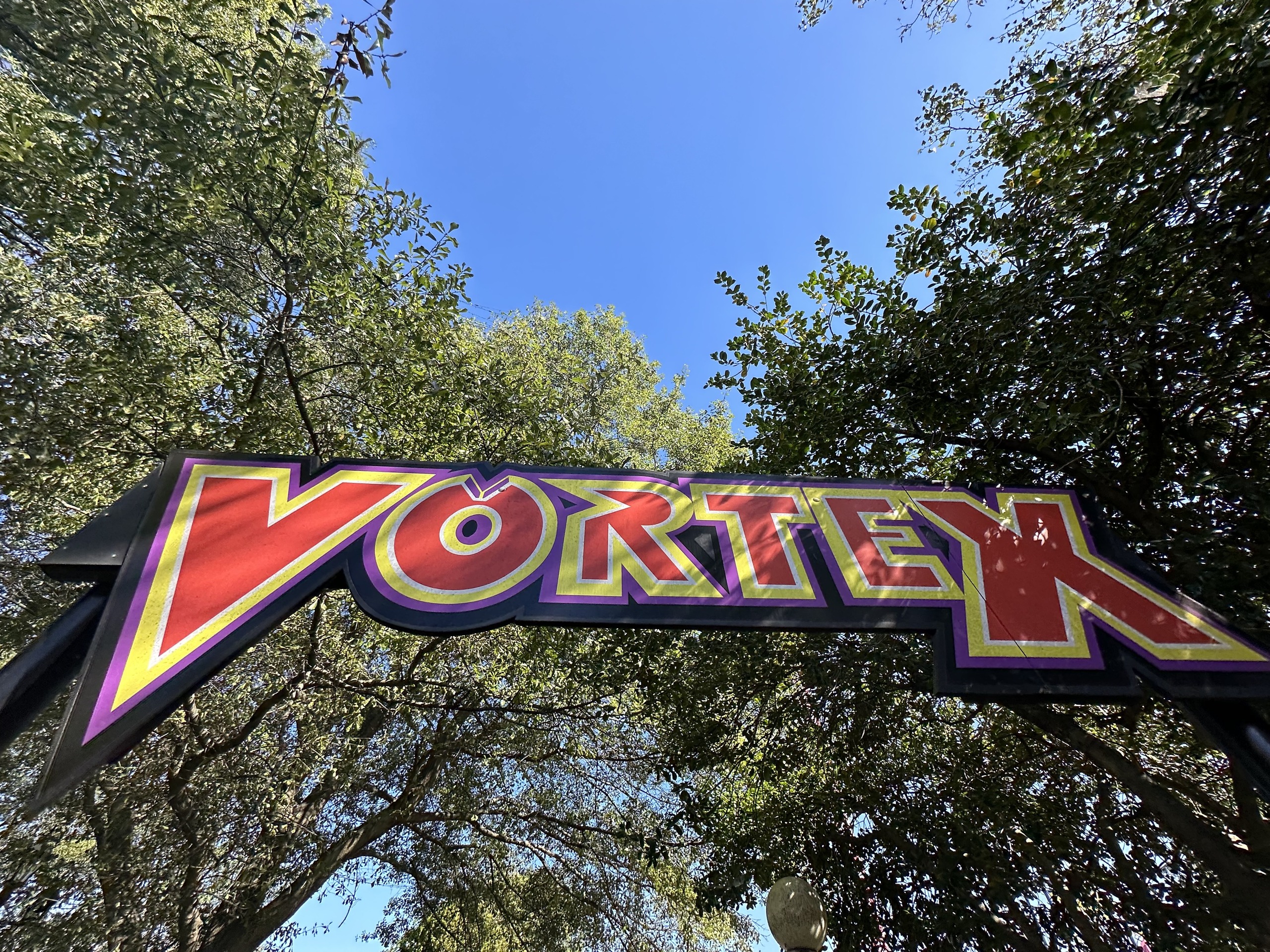 The Vortex sign framed by oak trees, Carowinds, October 2024