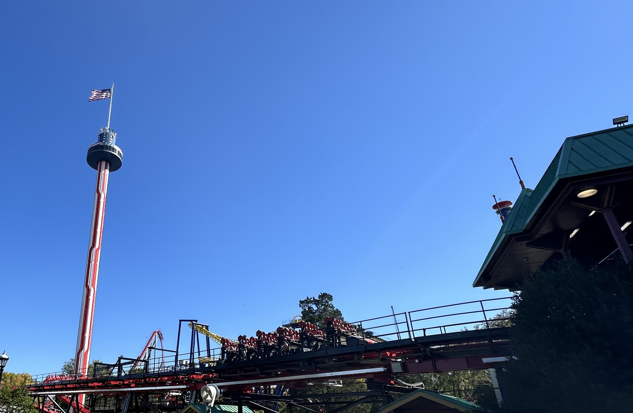 A Vortex stand-up train in the station with the Carowinds observation tower behind, October 2024
