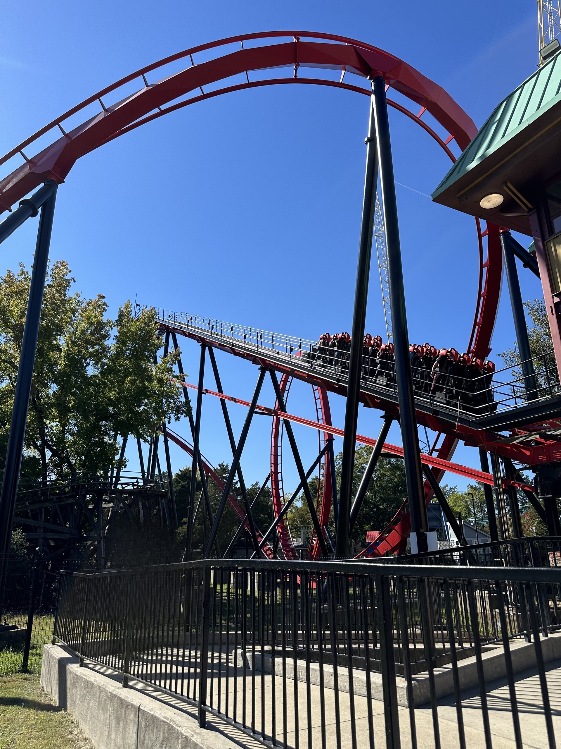 A Vortex stand-up train climbing the lift under the red loop, Carowinds, October 2024