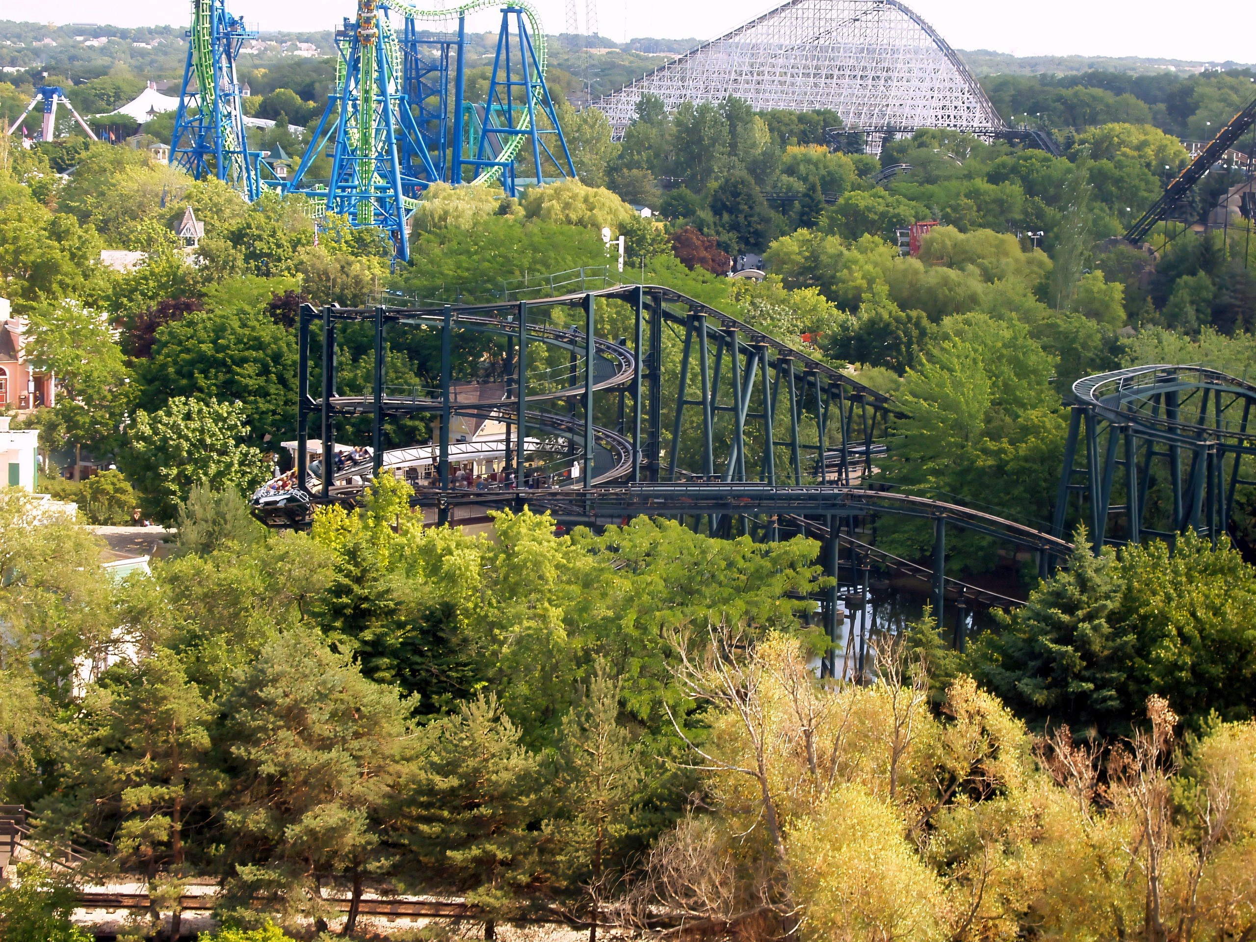 Whizzer's green track winding through the trees with the park's other coasters behind at Six Flags Great America, August 2005