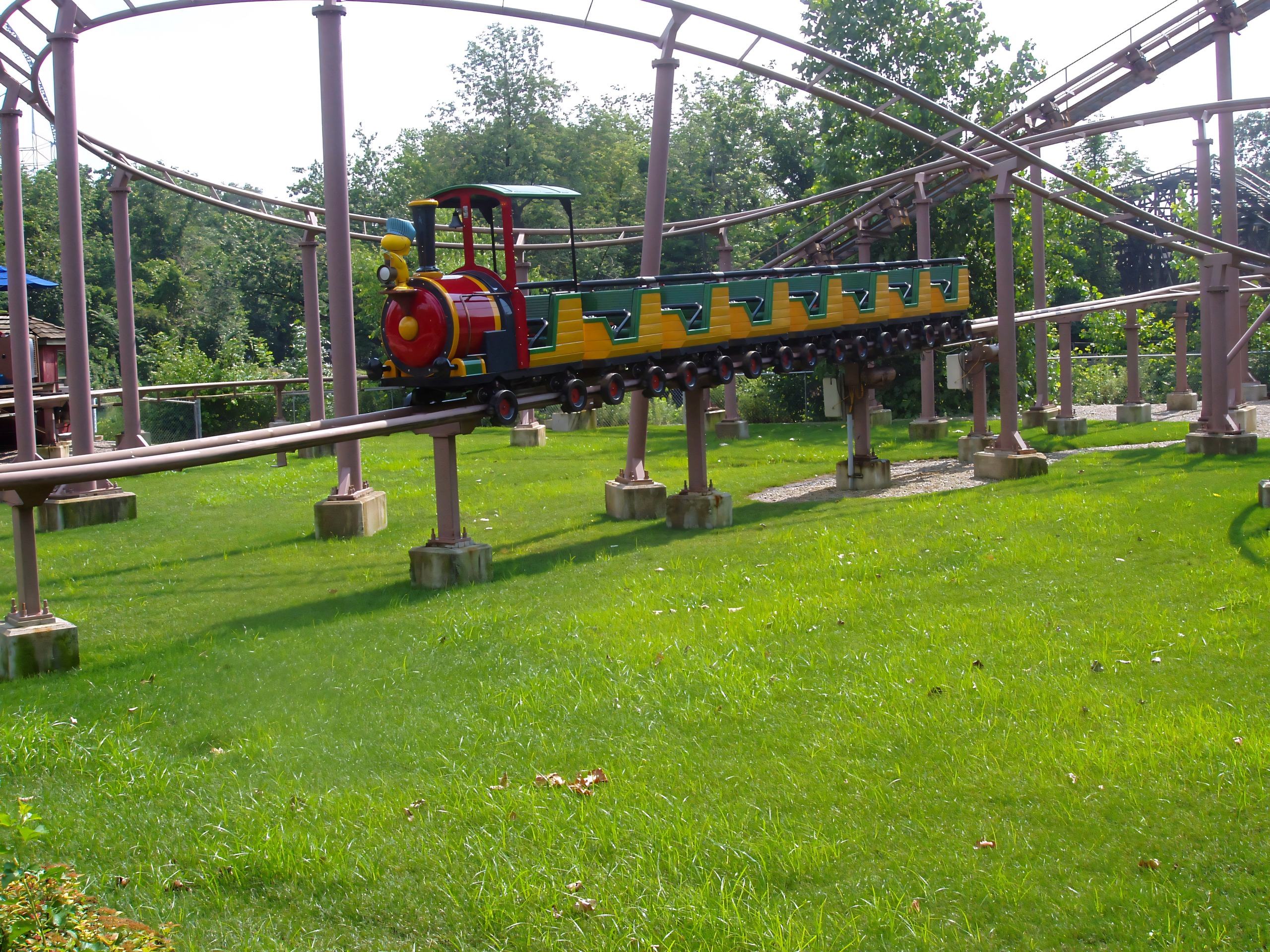 Empty train-themed coaster car on elevated track over lawn, Woodstock Express, July 2005