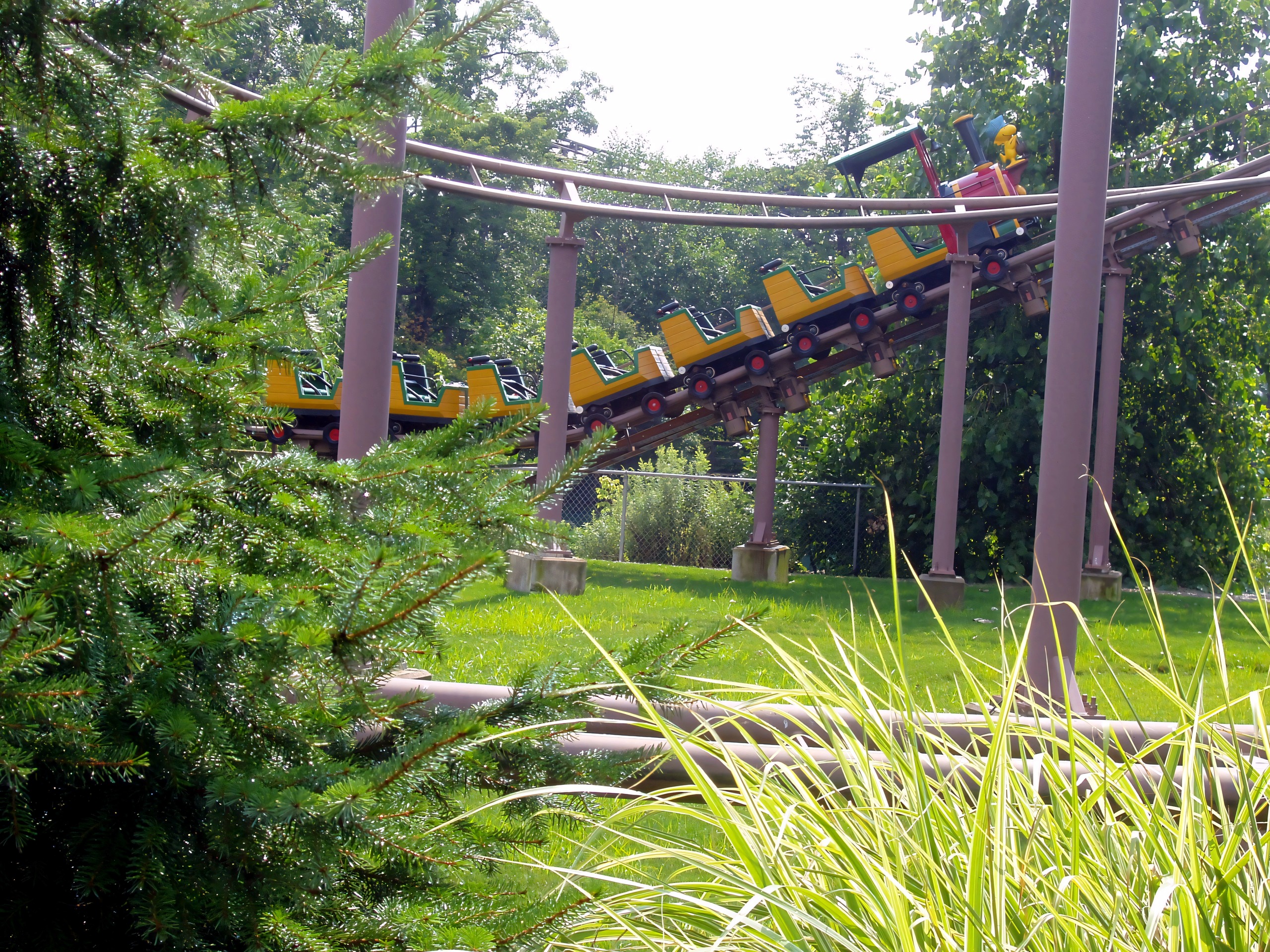 Train-style coaster car descending lift hill through trees, Woodstock Express, July 2005