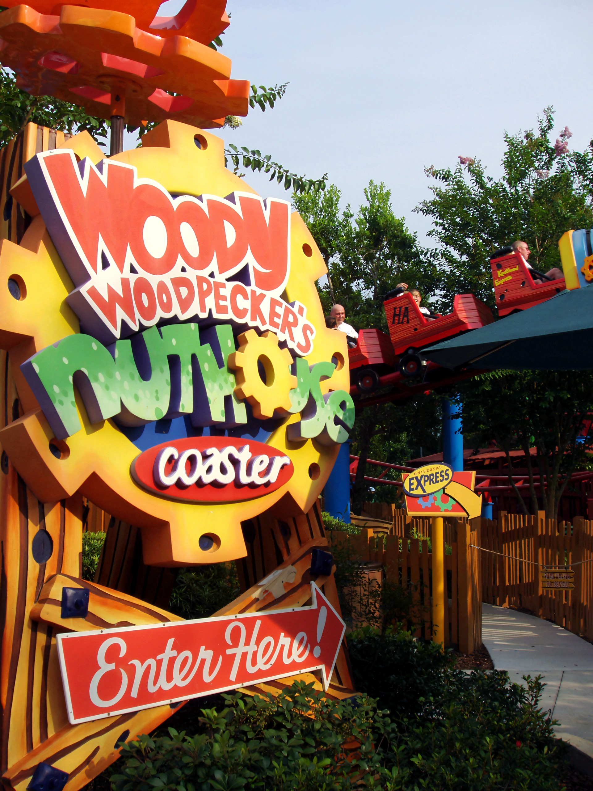 The Woody Woodpecker's Nuthouse Coaster entrance sign with a train passing behind at Universal Studios Florida, June 2006