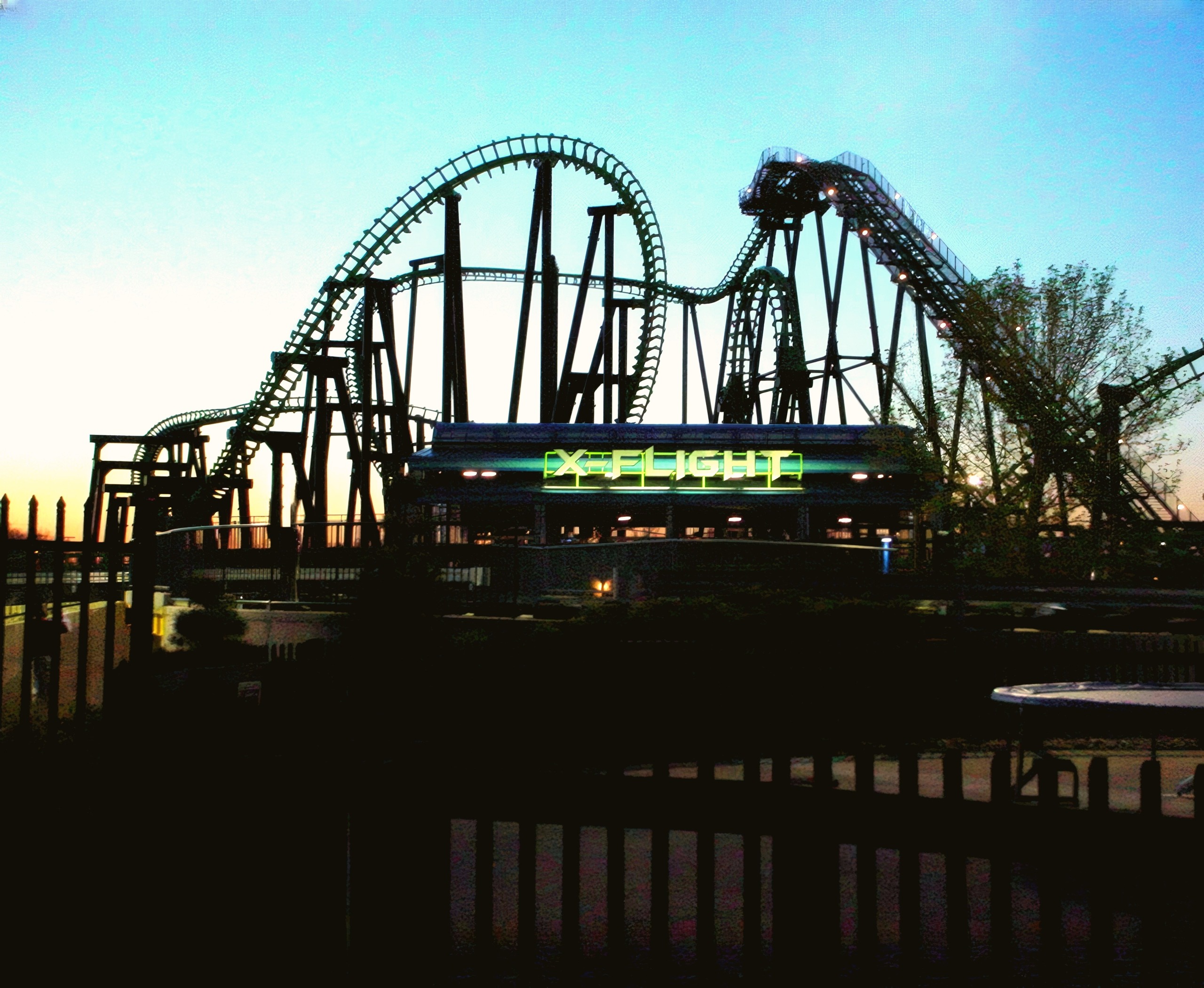 X-Flight silhouetted against the twilight sky with its station sign lit, Six Flags Worlds of Adventure, May 2002