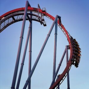 A Banshee train with riders' legs dangling on the outside of the maroon curve, Kings Island, July 2022
