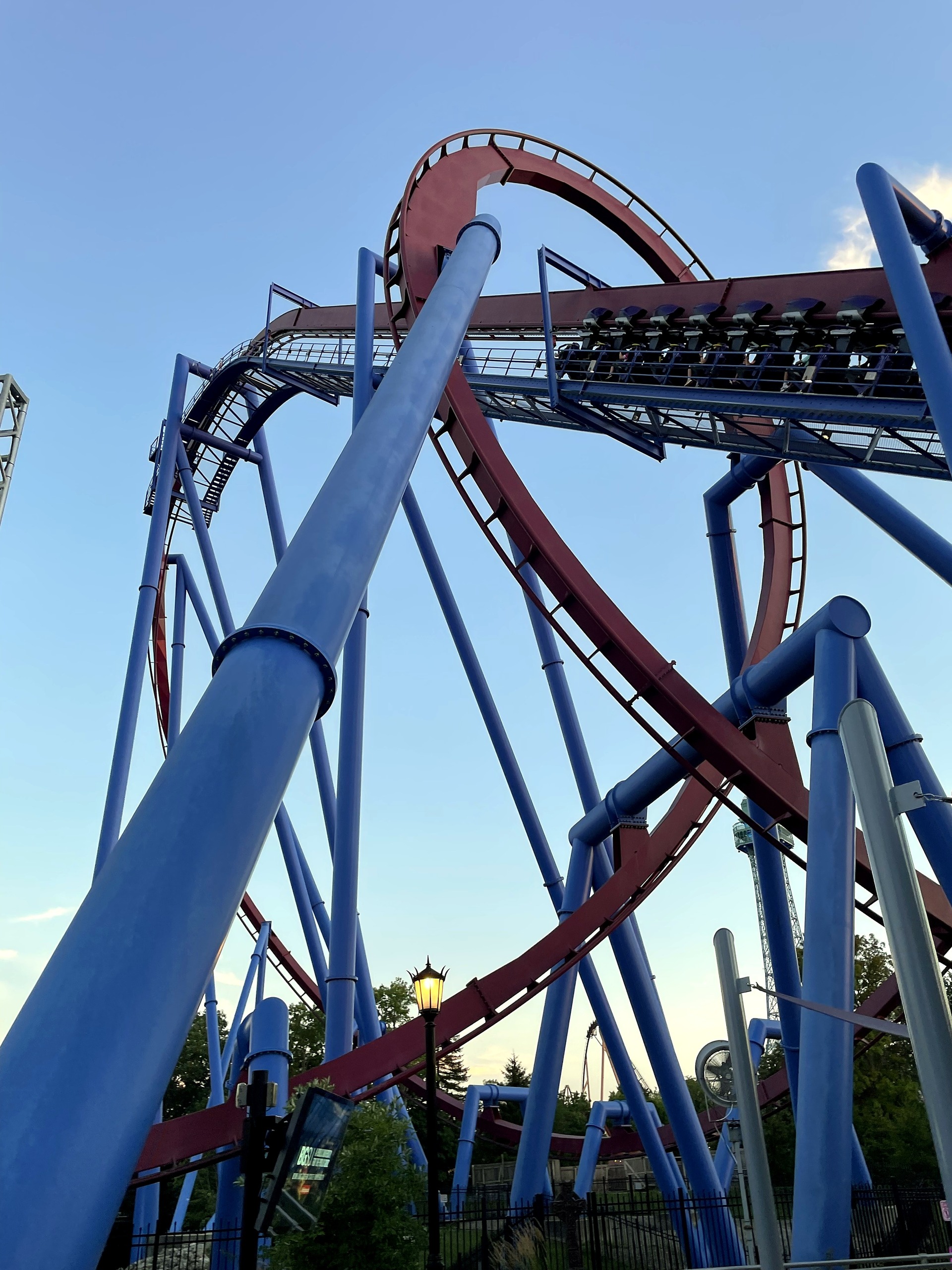 Looking up a blue support column at a Banshee train on the lift, Kings Island, July 2022