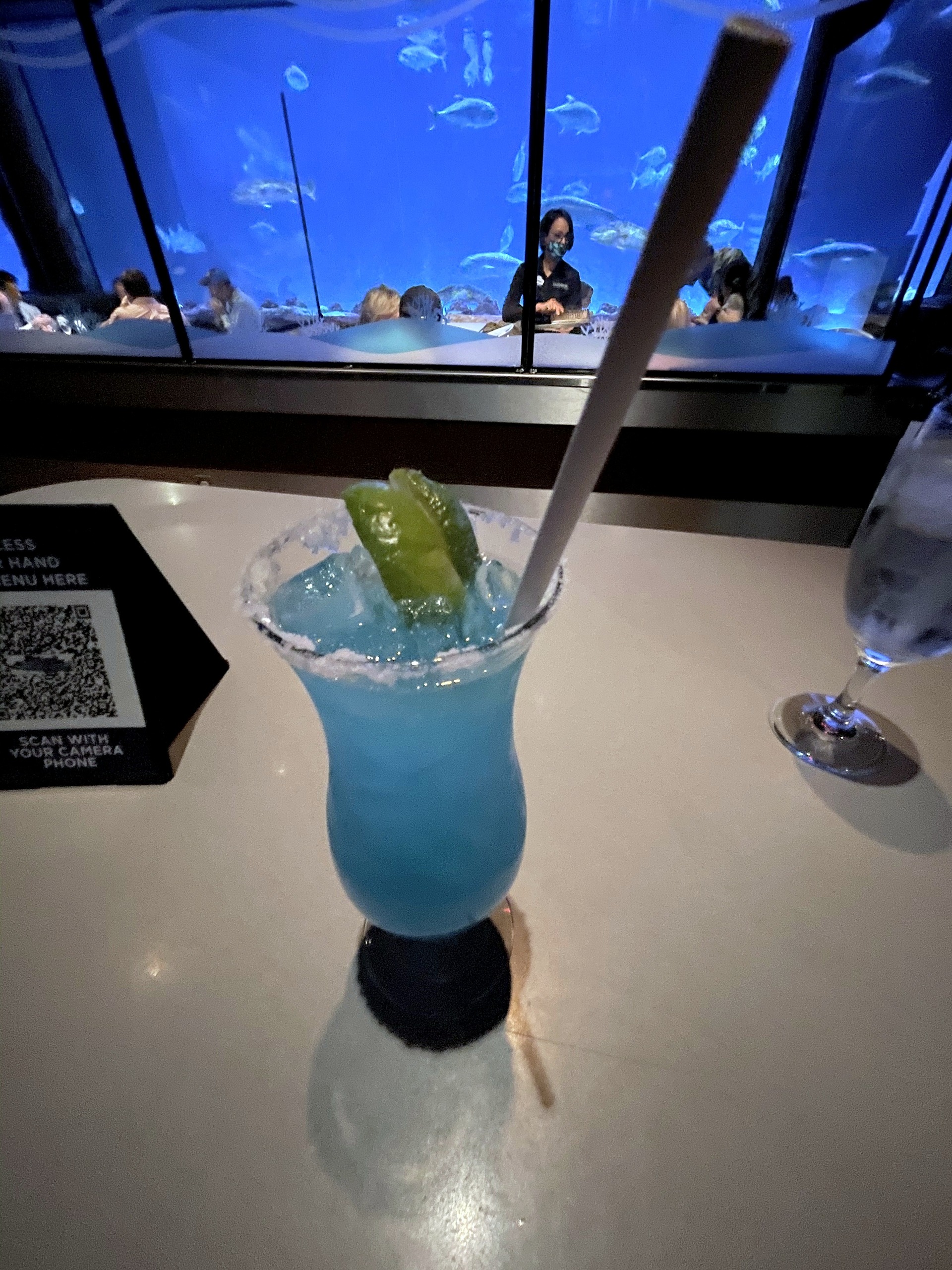 A blue cocktail with a lime wedge at Sharks Underwater Grill at SeaWorld Orlando, March 2021