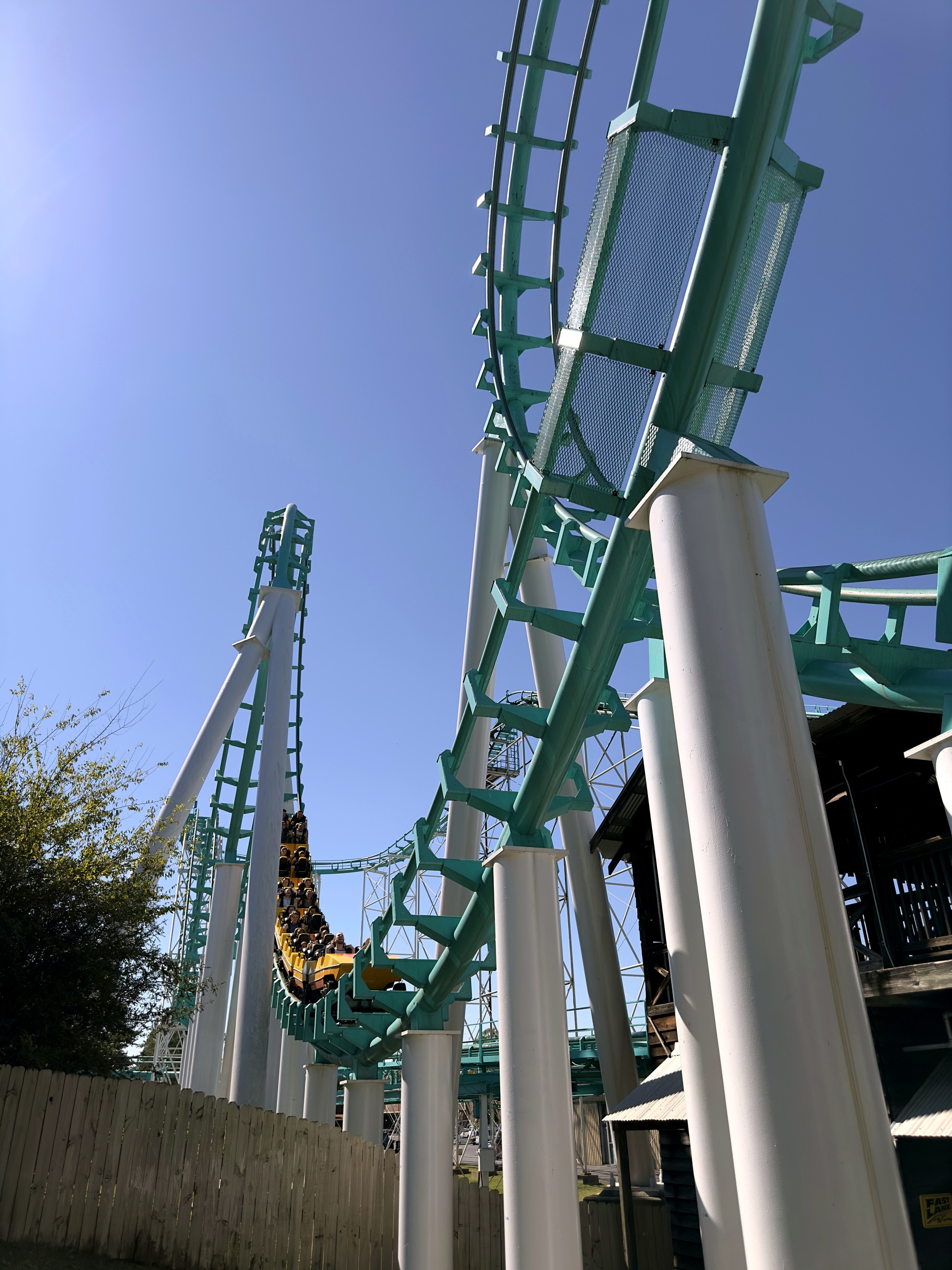 Carolina Cyclone's teal loop and white supports, with a train on the far side at Carowinds, October 2024