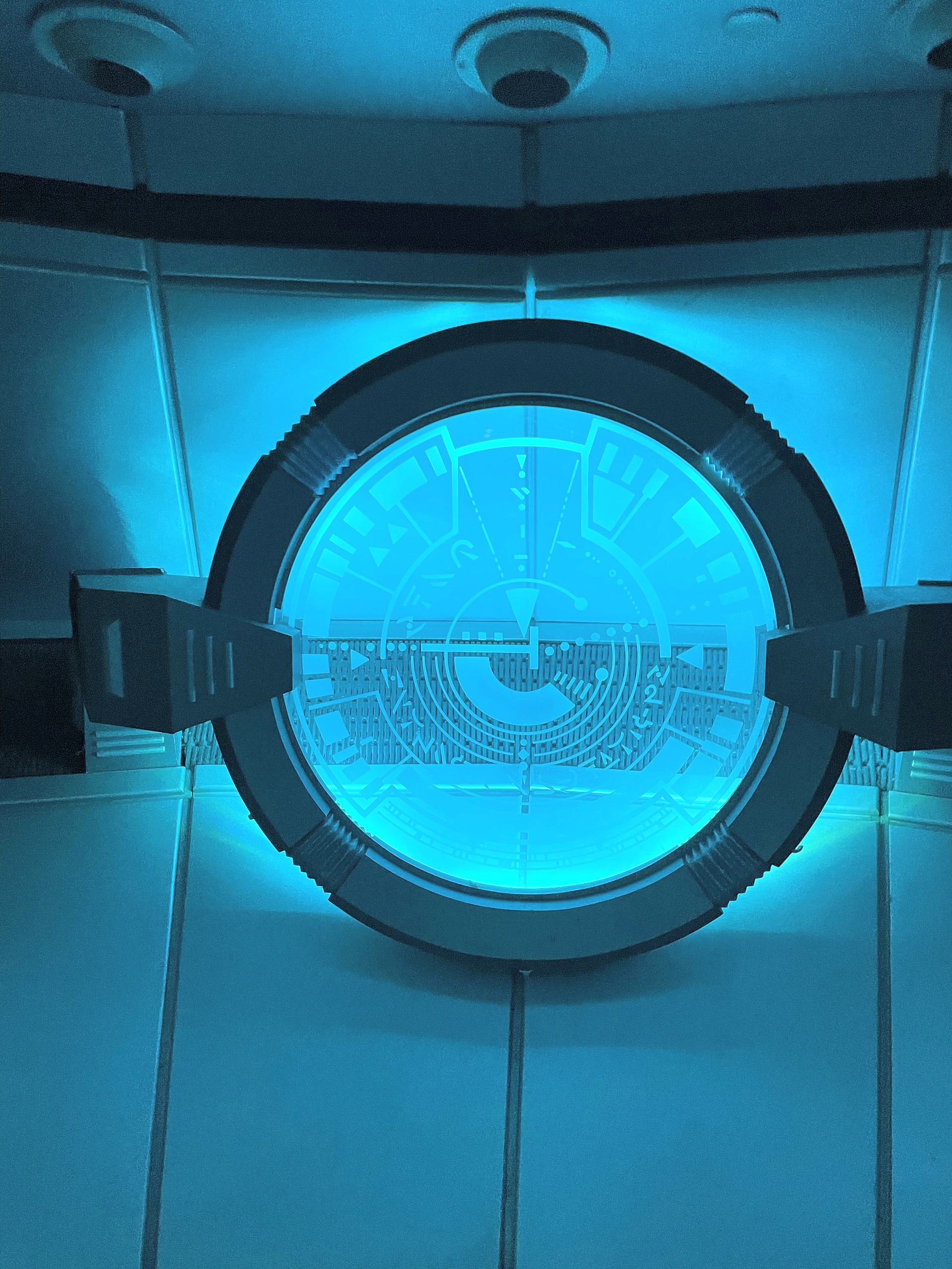 A round hatch glowing blue inside the Flight of Fear saucer, Kings Island, July 2022